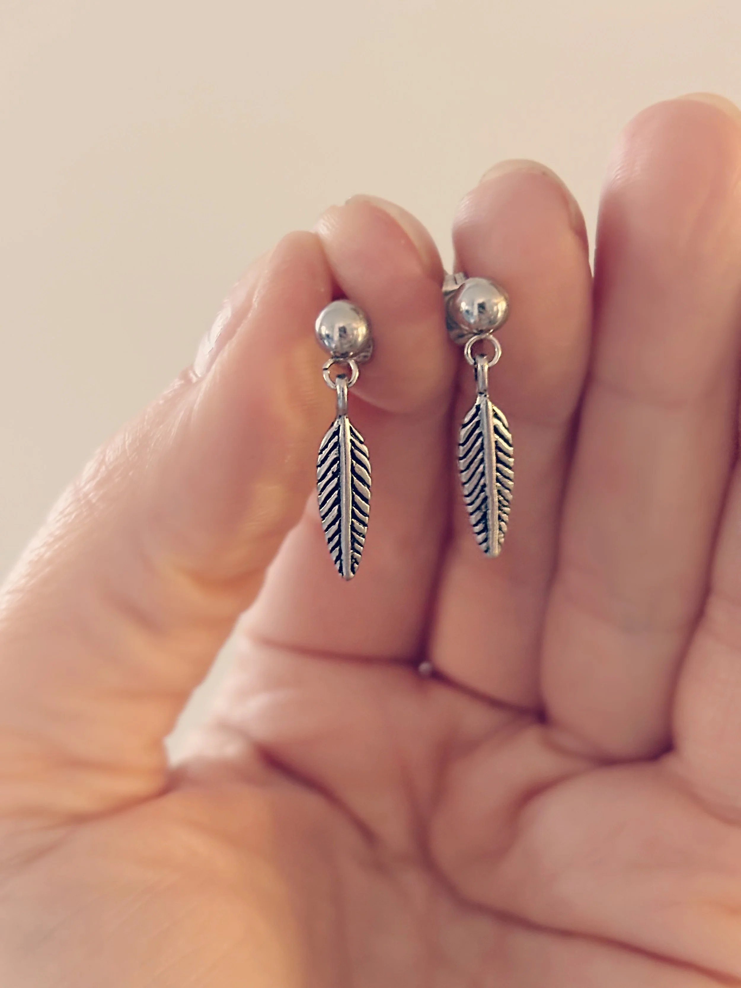 Boucles d’oreilles Naia en acier inoxydable argent, motif plume vue de près – Tokade