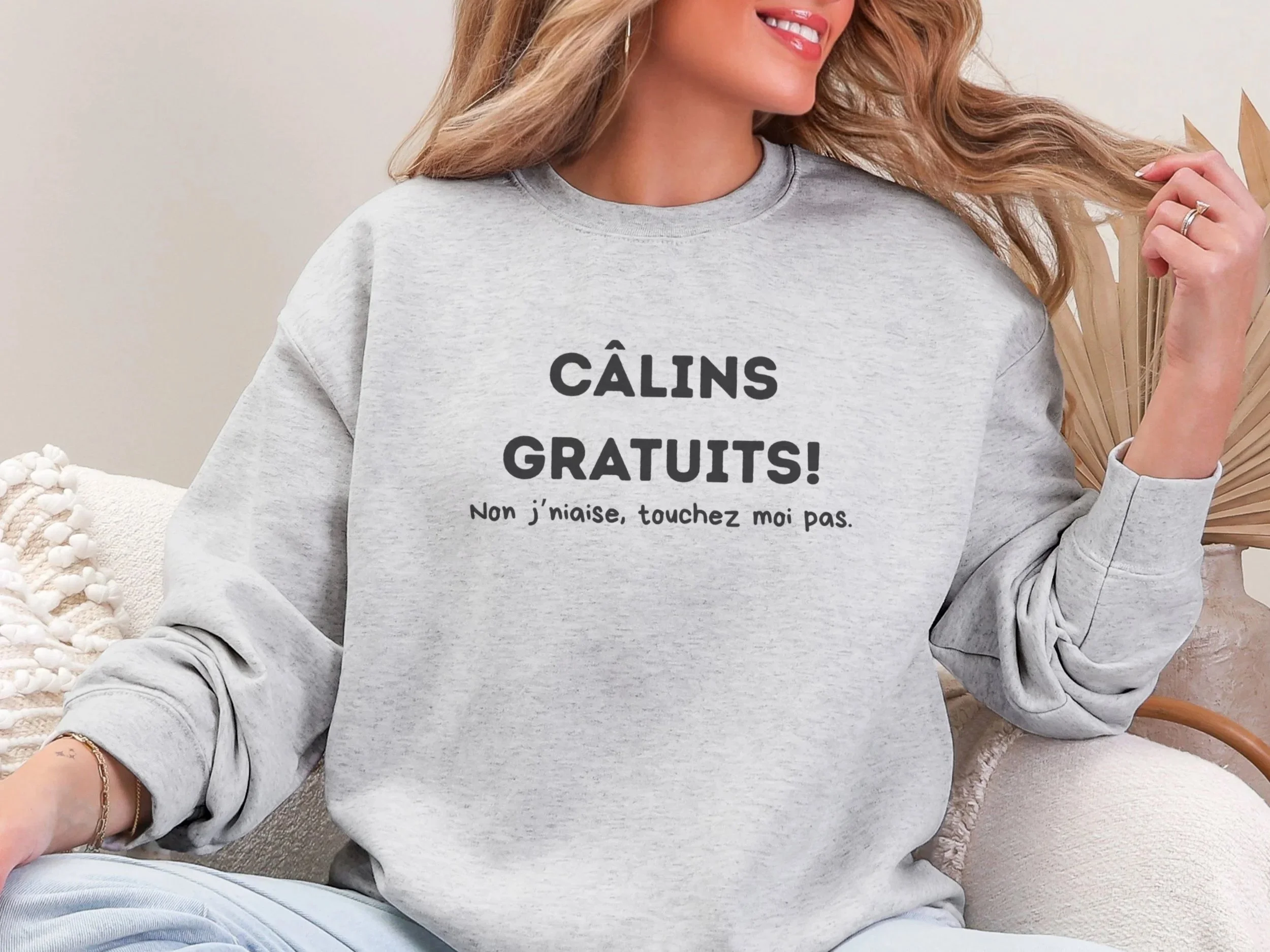 Face avant du coton ouaté humoristique avec l’inscription “Câlins gratuits! Non j’naise, touchez-moi pas”.