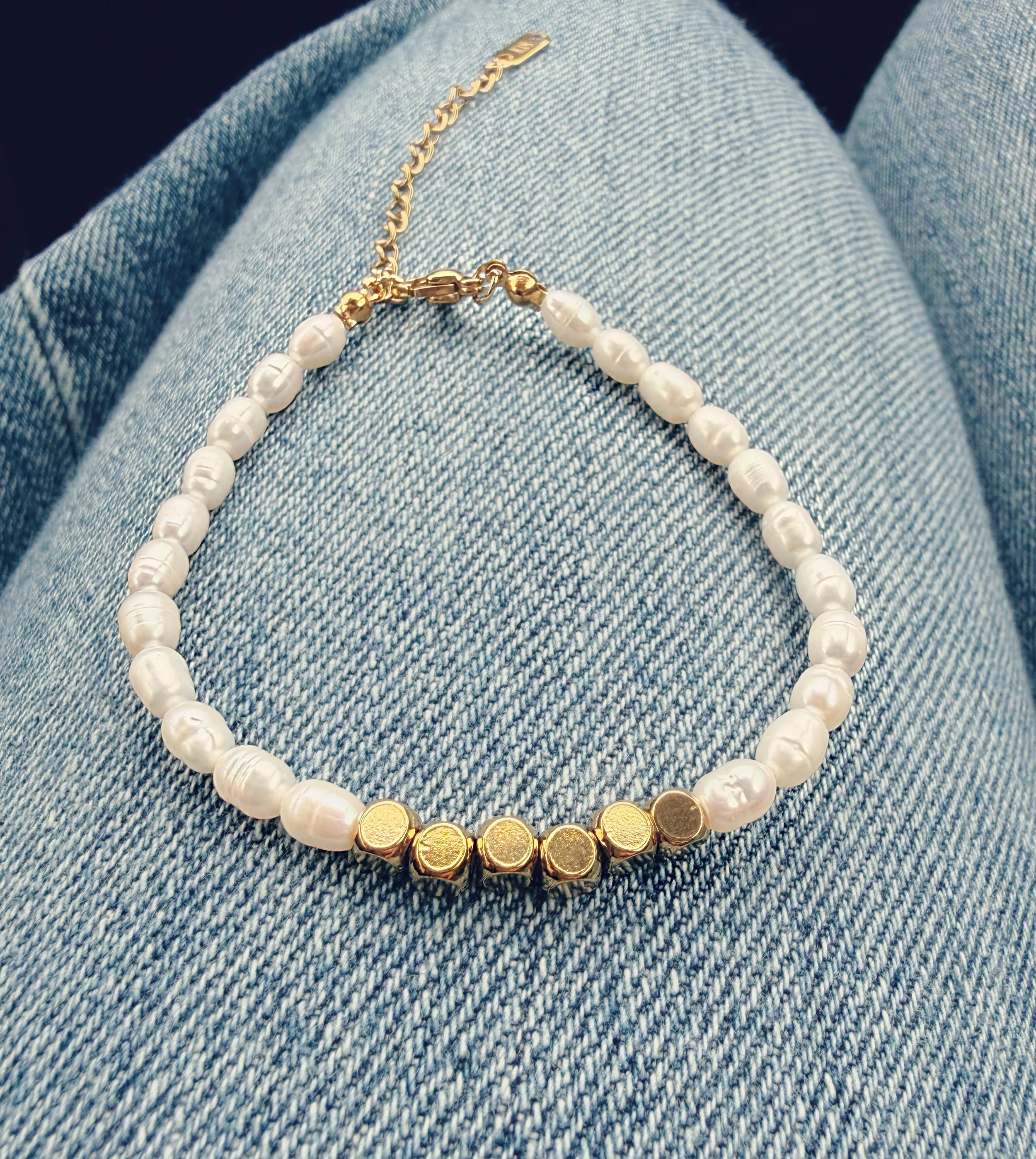 Bracelet en perles et doré sur fond denim, bijou minimaliste au quotidien