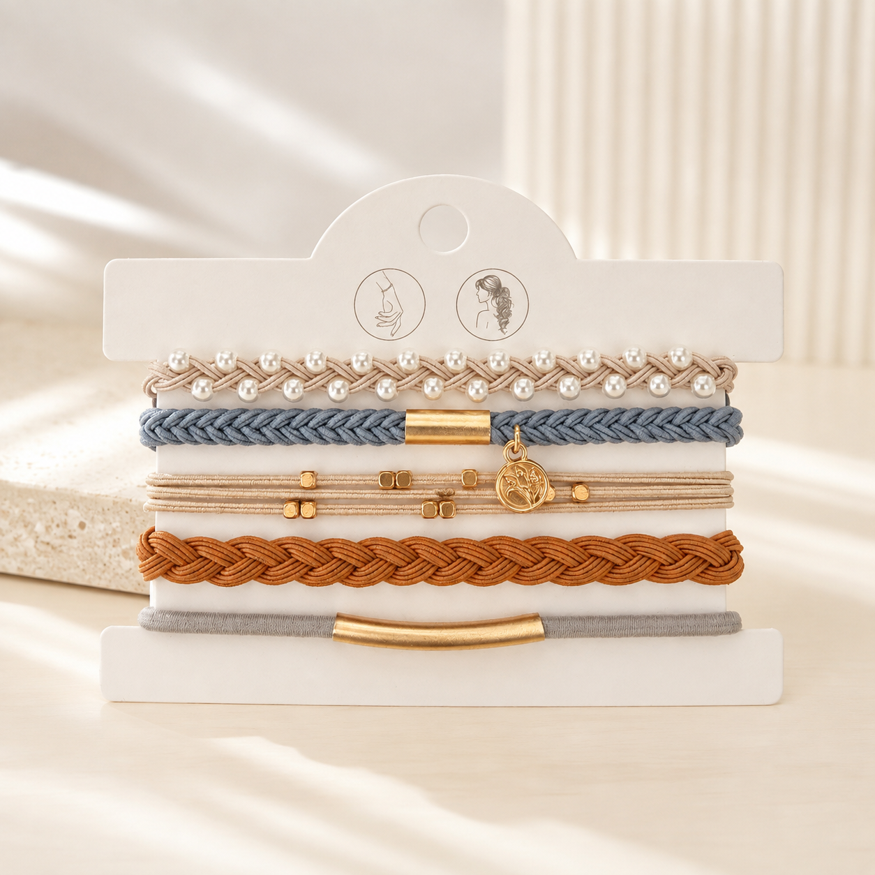 Lot de 5 élastiques à cheveux et bracelets 2-en-1 bleu gris, camel, beige et perles avec détails dorés.
