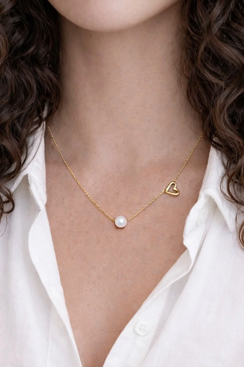 Le collier Joan porté avec une chemise blanche pour un style doux et intemporel. Un bijou délicat qui illumine le décolleté et se porte facilement au quotidien.