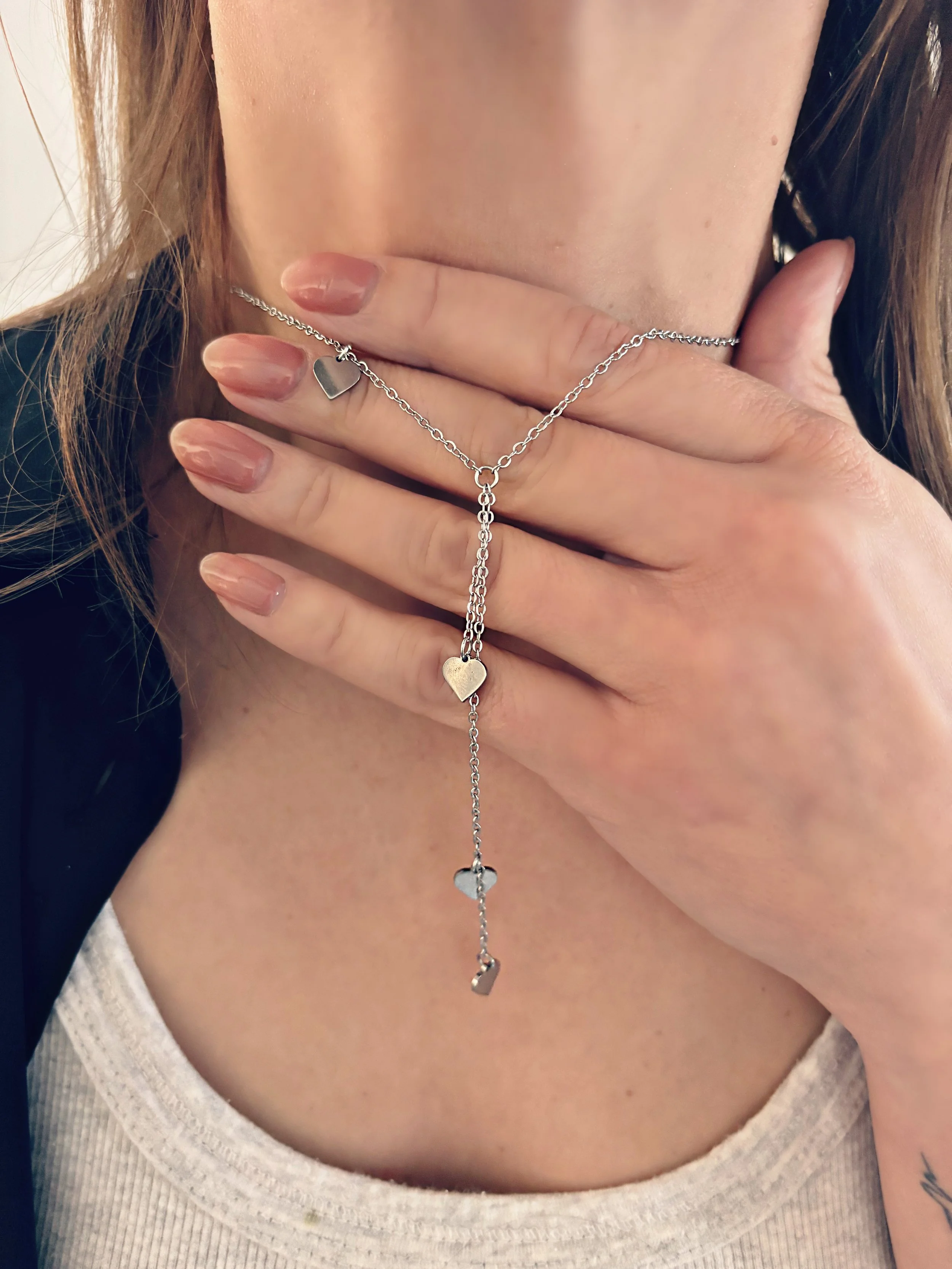 Gros plan sur le collier pour illustrer le détail des pendentifs et la finition soignée de l’acier inoxydable.