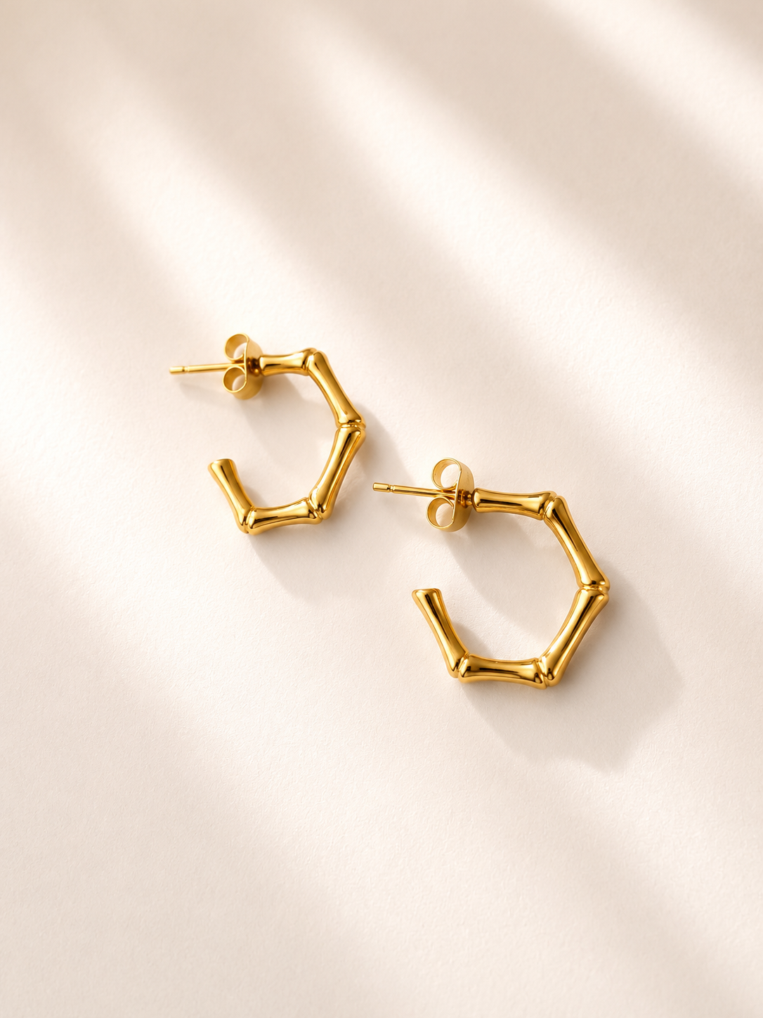 Paire de boucles d’oreilles Viky en acier inoxydable doré avec design géométrique inspiré du bambou sur fond blanc.