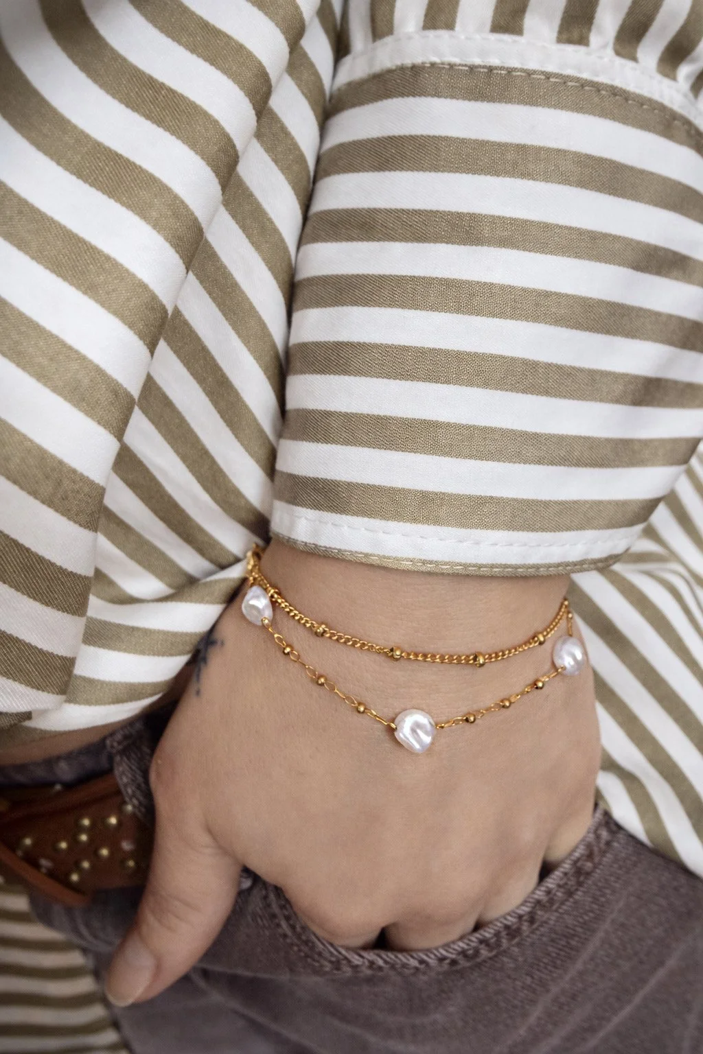 Bracelet doré avec perles iridescentes porté au poignet-Tokade