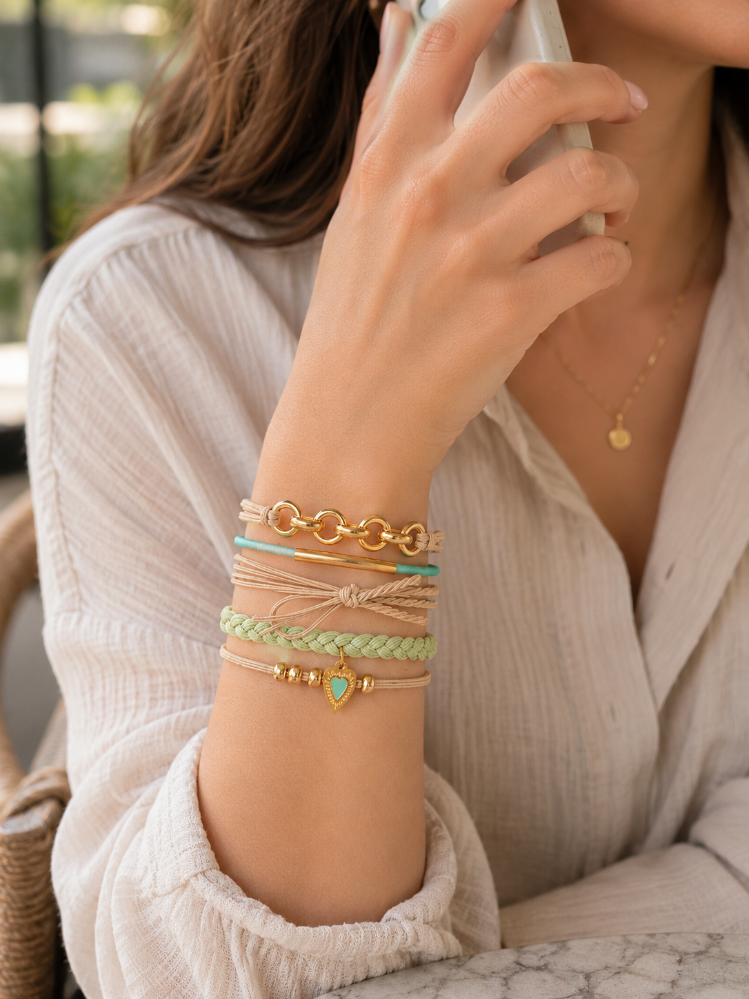 Élastiques à cheveux et bracelets 2-en-1 beige, vert sauge et turquoise portés au poignet d’une femme - Tokade