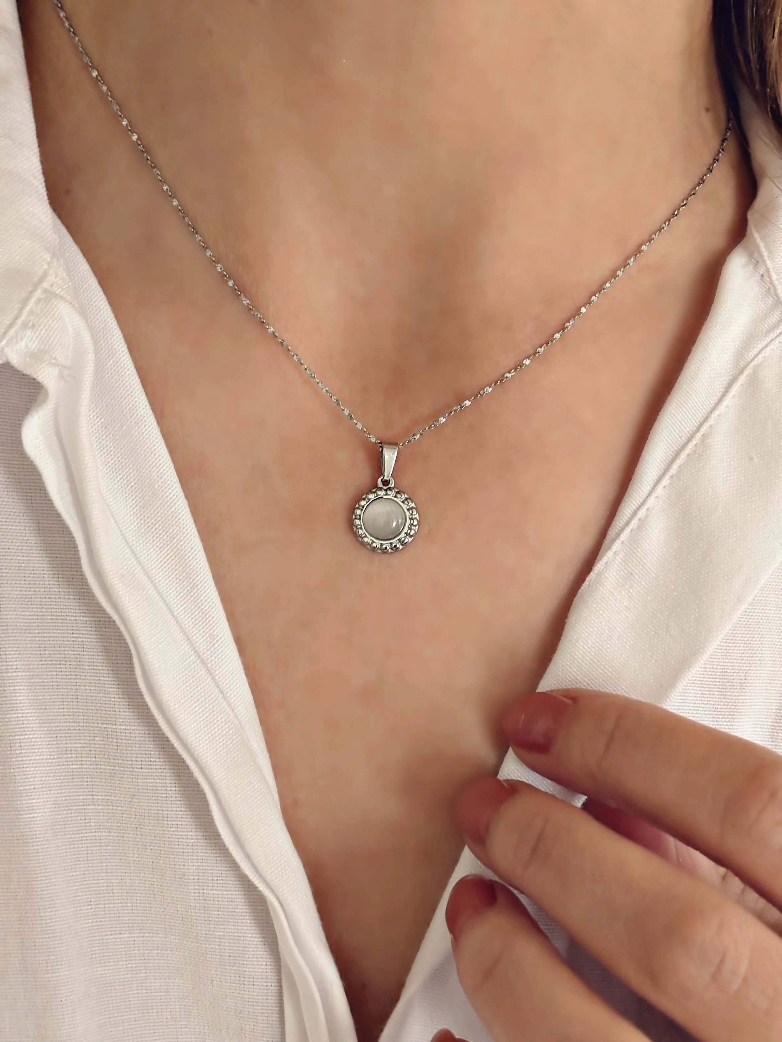 Le collier présenté dans la main, montrant les détails du pendentif et la finesse de la chaîne.