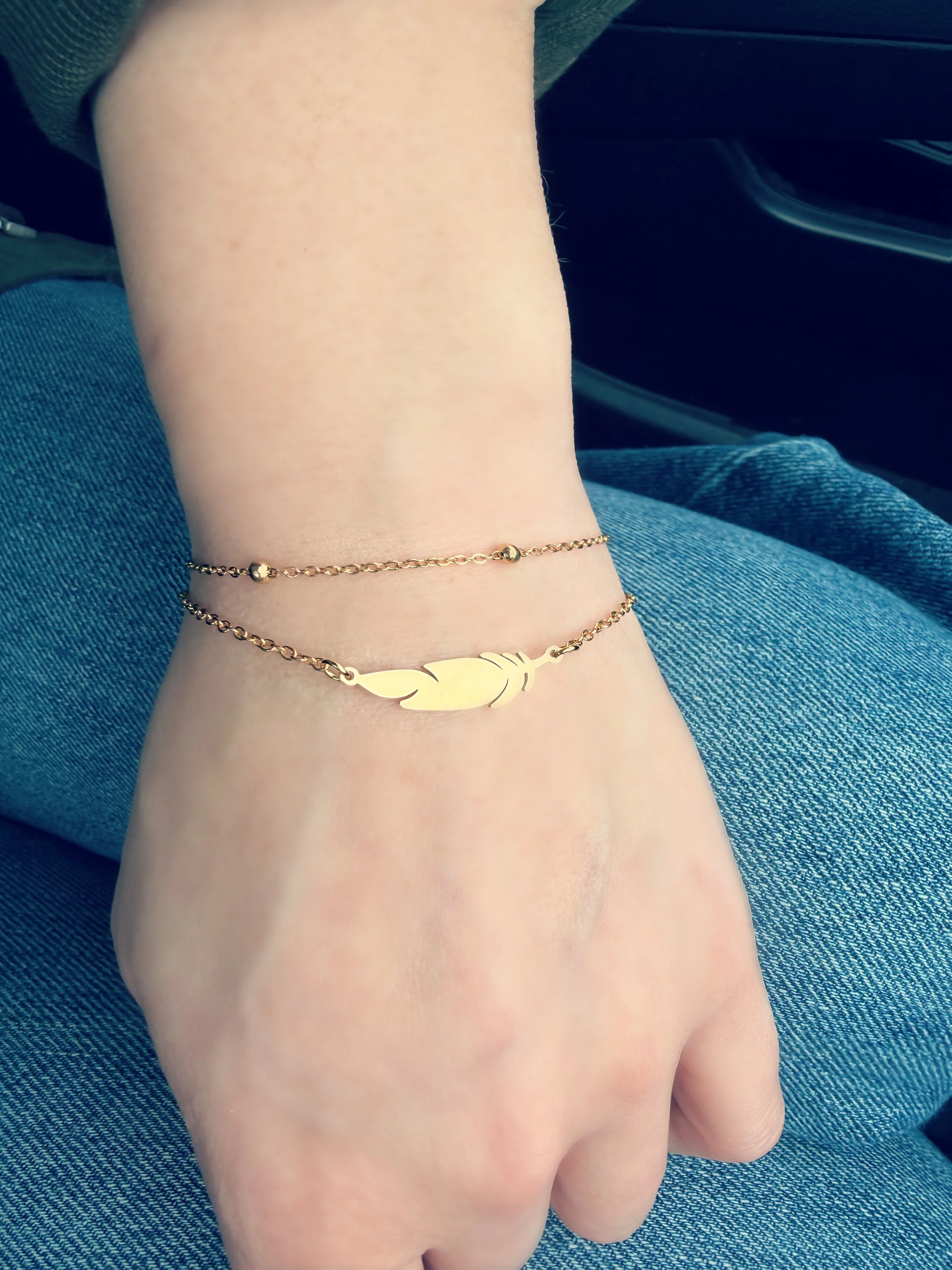 Bracelet délicat avec pendentif plume sur la main-Tokade