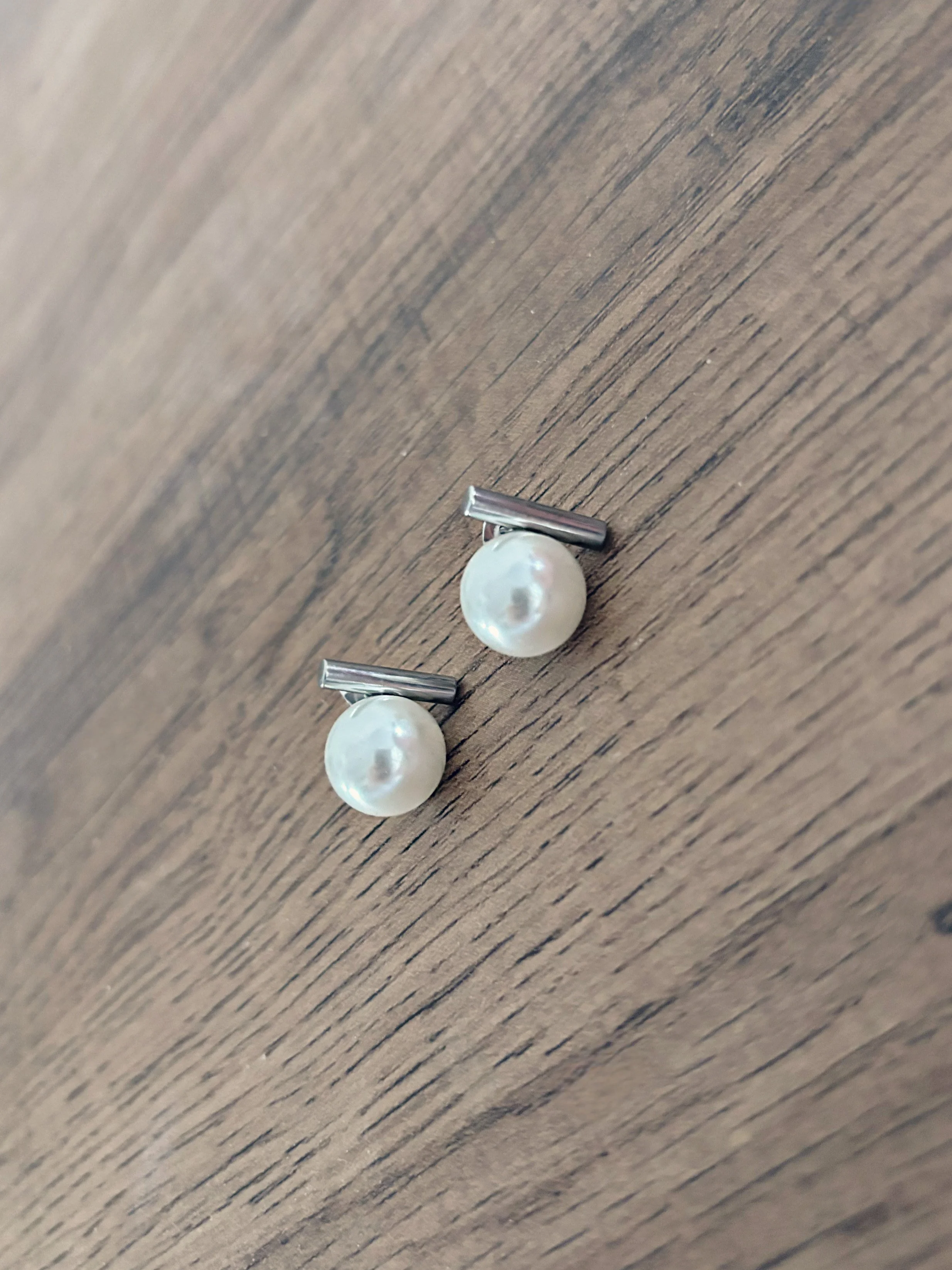 Boucles d’oreilles Alicia posées sur une surface en bois, vue rapprochée.