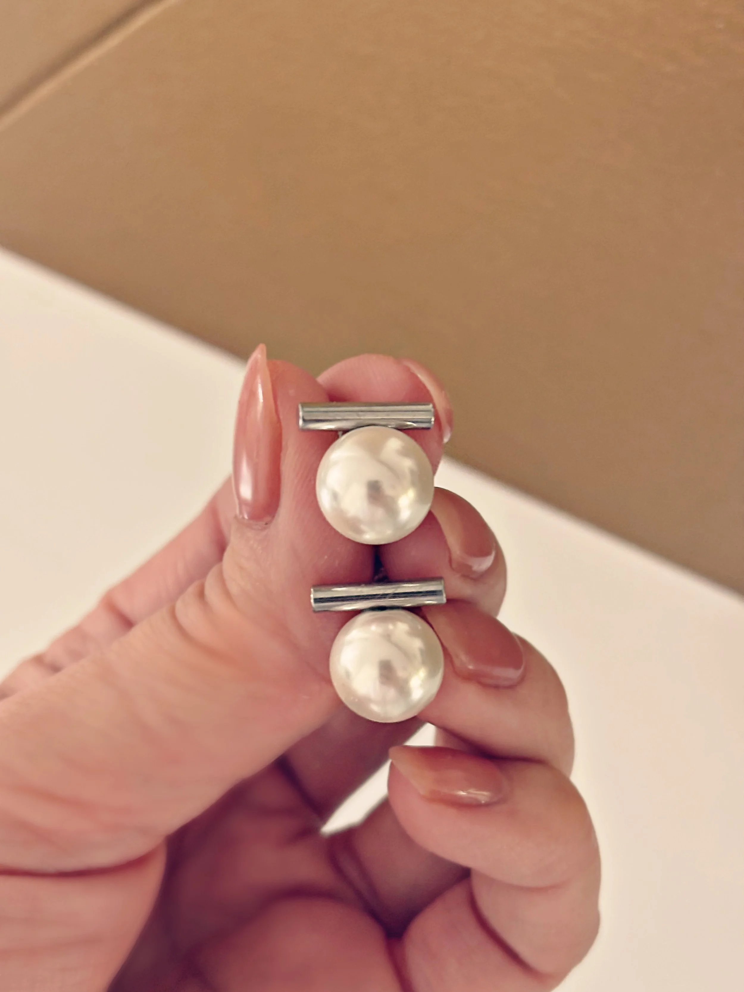 Boucles d’oreilles Alicia tenues dans la main, montrant leur brillance et leur taille.