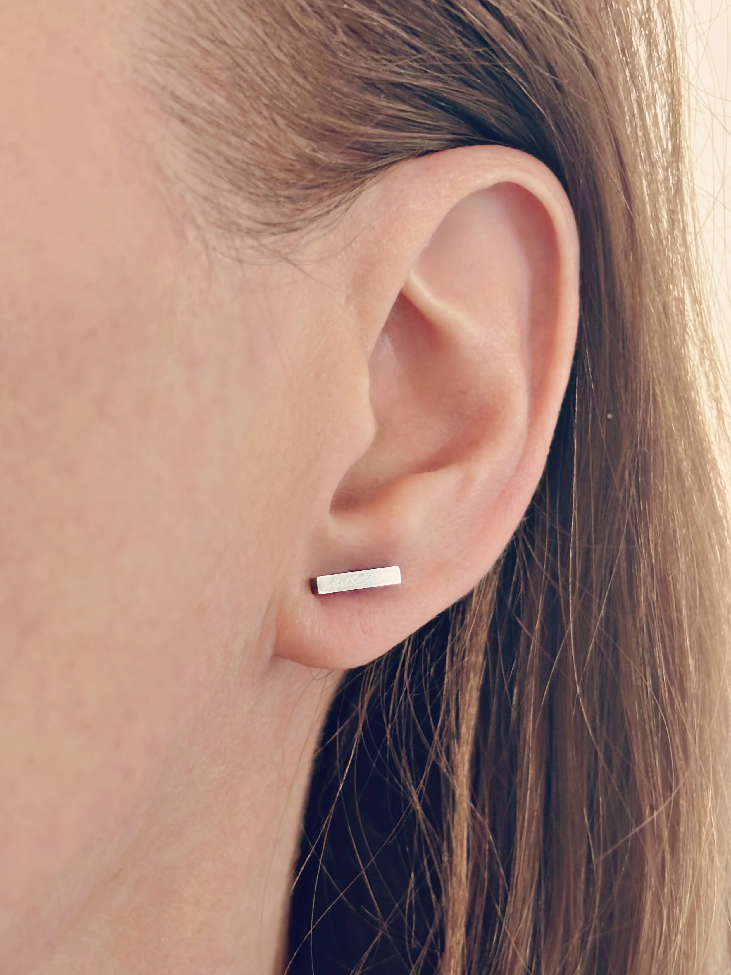 Boucles Linéa portées, mettant en valeur leur design minimaliste et raffiné.