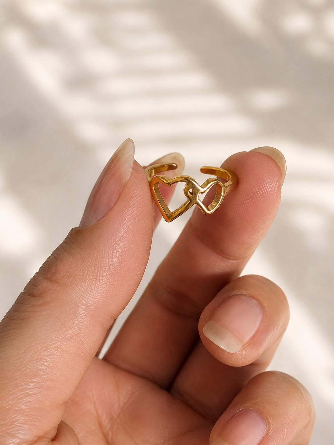 Bague d’orteil Julie en acier inoxydable doré avec deux cœurs entrelacés ajustable. Par Tokade