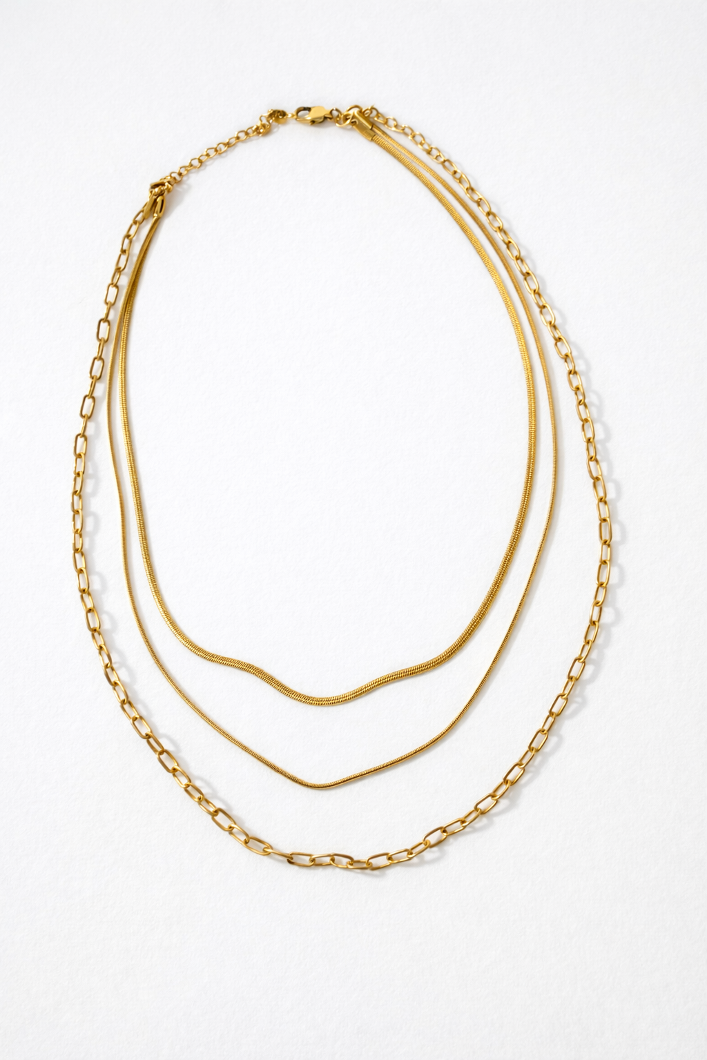 Collier multi-chaînes doré présenté sur une coiffeuse