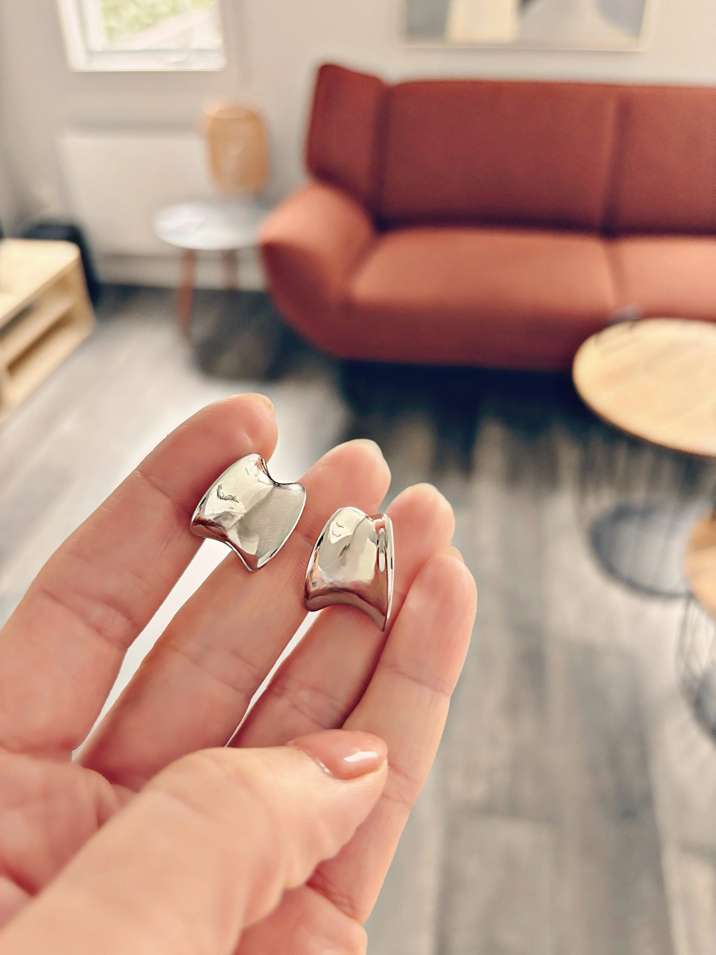 Gros plan des boucles Mila tenues dans la main, vue rapprochée sur les détails.