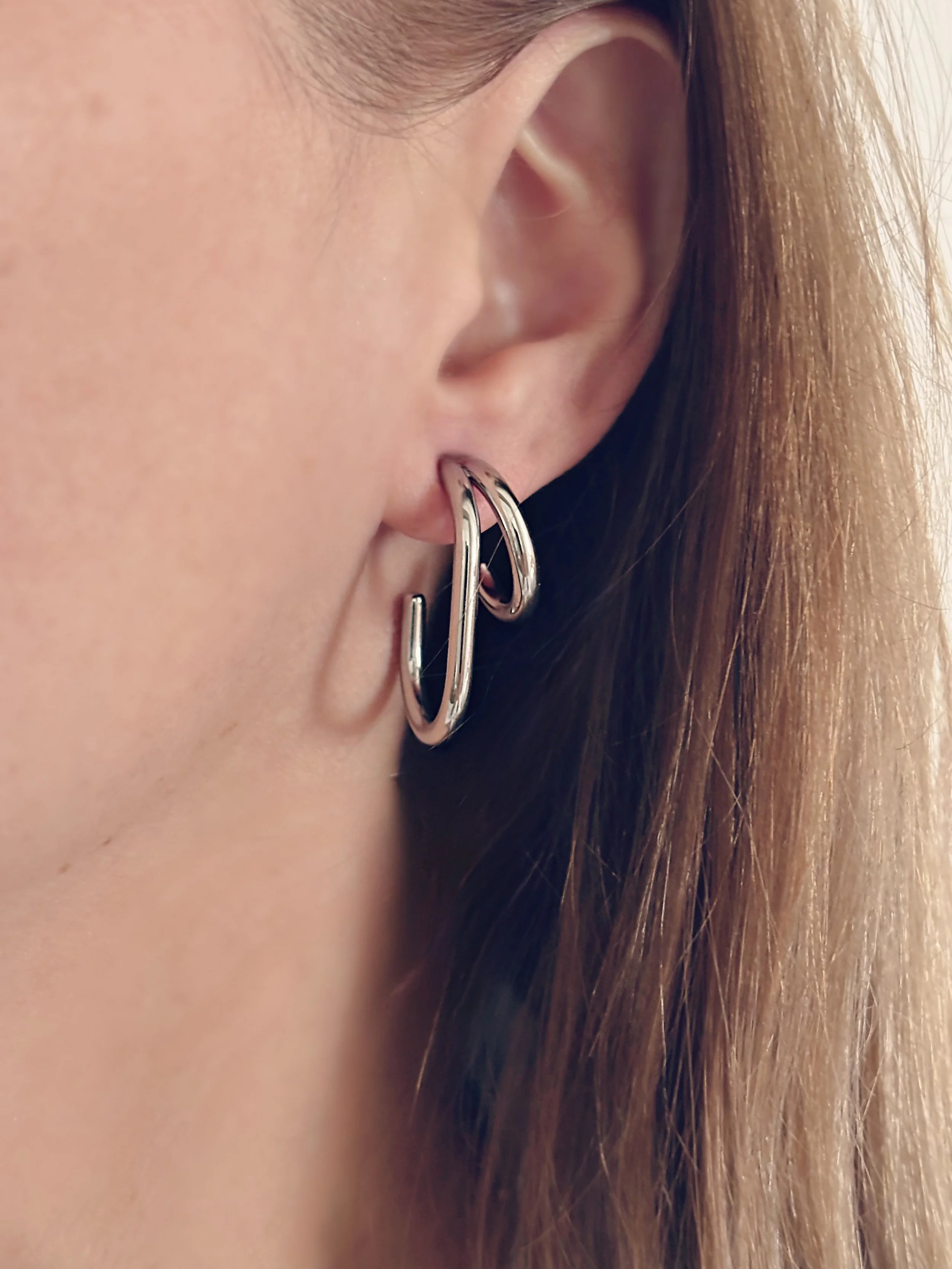 Gros plan sur les boucles Zoé portées, style moderne et audacieux.