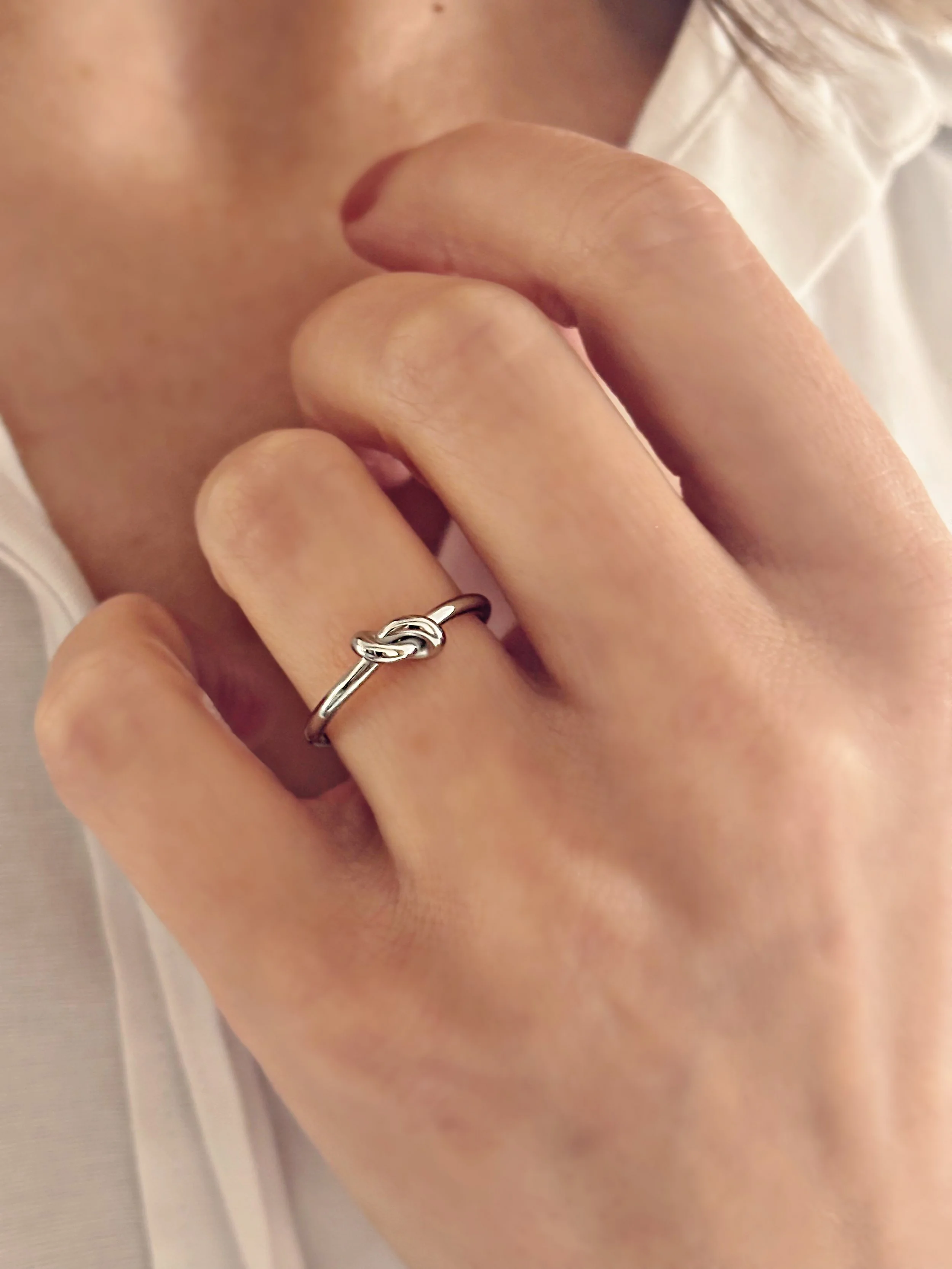 Bague June portée, mettant en valeur le petit nœud délicat et minimaliste.