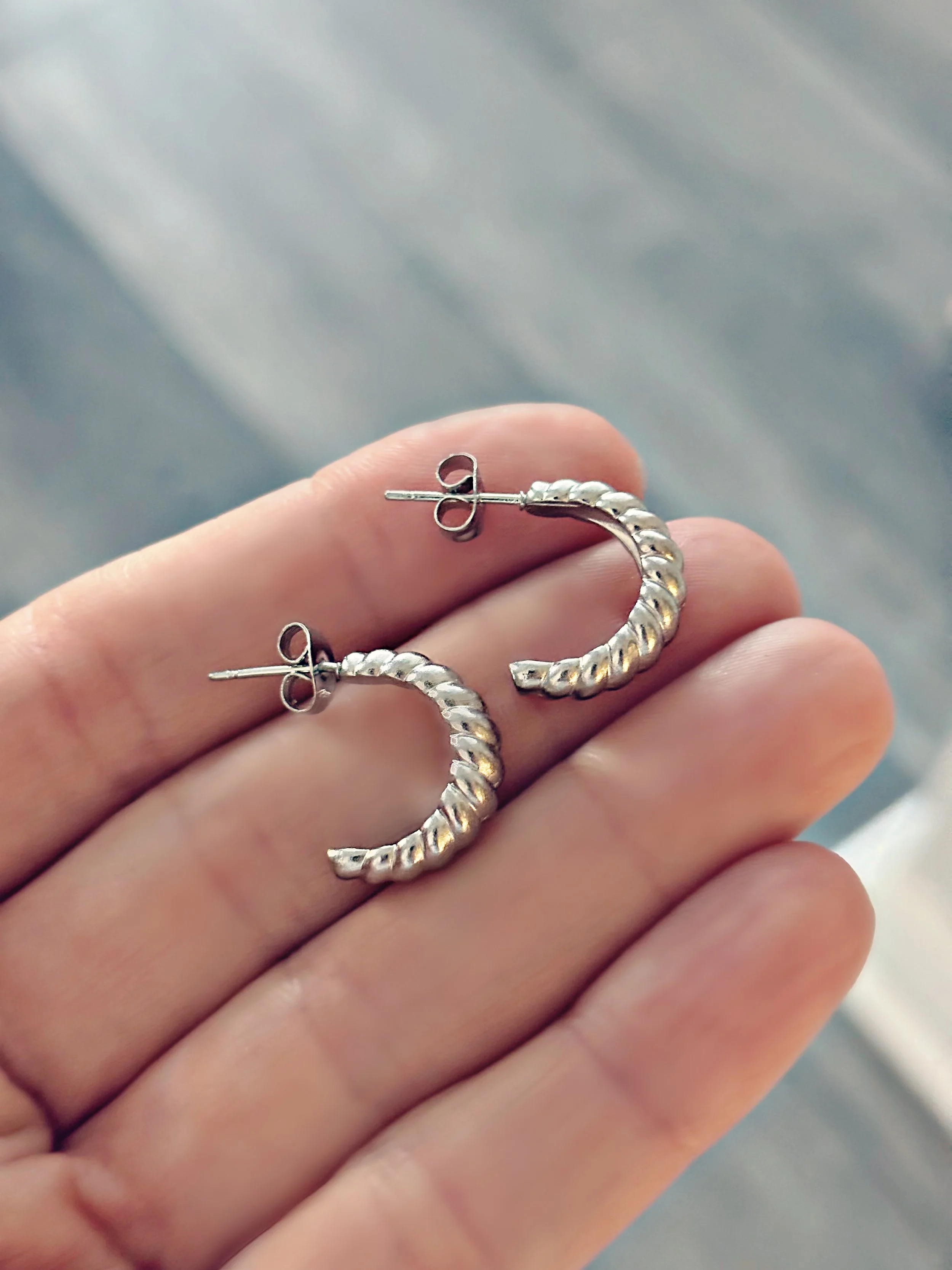 Boucles d’oreilles Talia en acier inoxydable argent, design torsadé brillant vues de près – Tokade