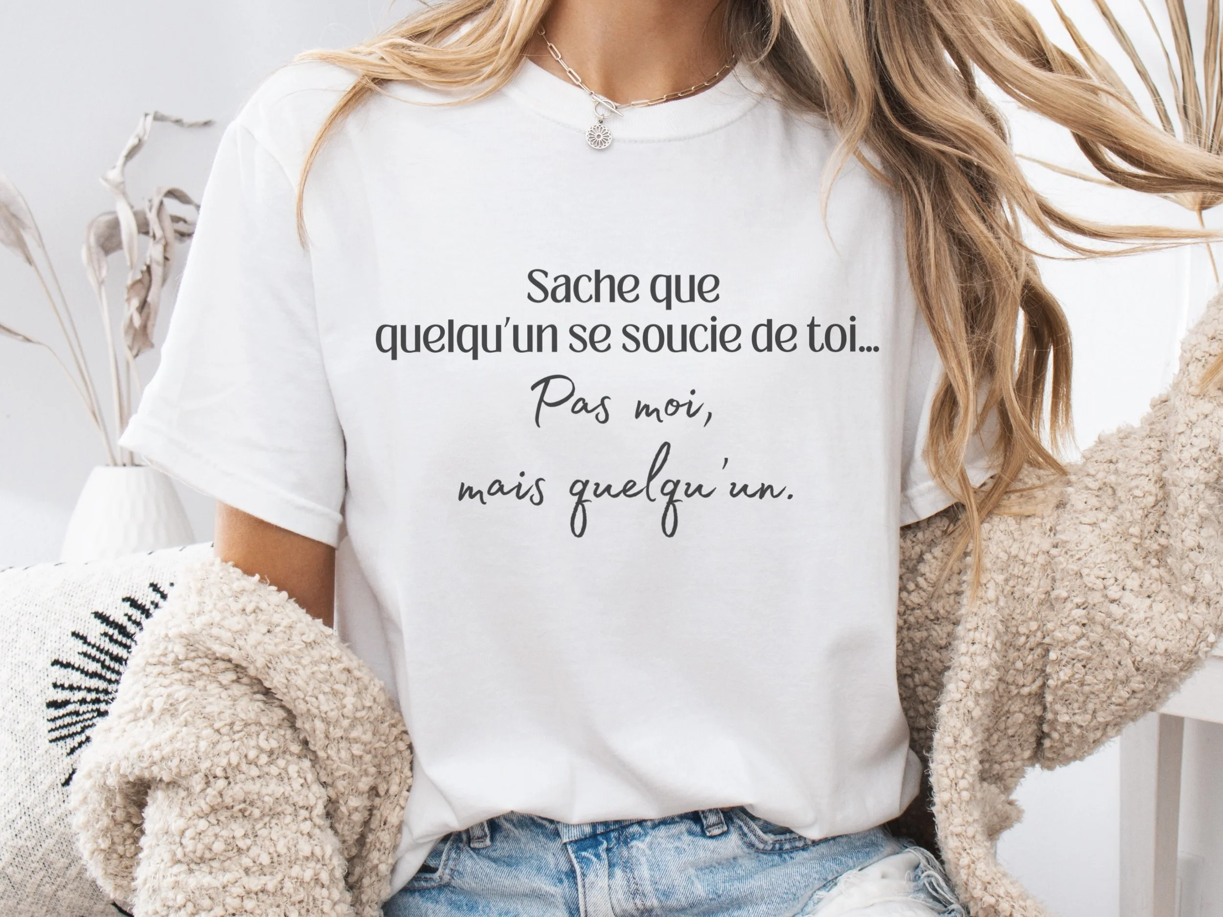 Femme portant un t-shirt blanc avec l’inscription « Sache que quelqu’un se soucie de toi… Pas moi, mais quelqu’un. » — Tokade