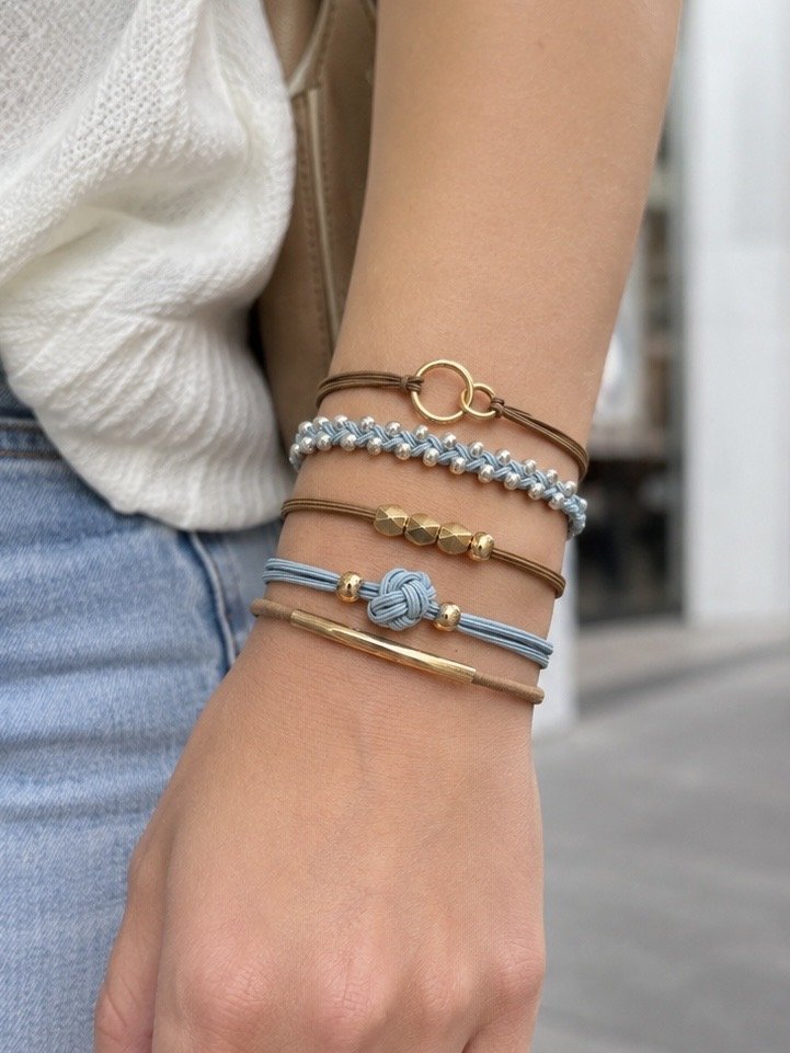 Lot de 5 élastiques à cheveux et bracelets 2-en-1 bleu pâle, beige et doré avec perles, anneaux entrelacés, billes facettées et nœud décoratif.