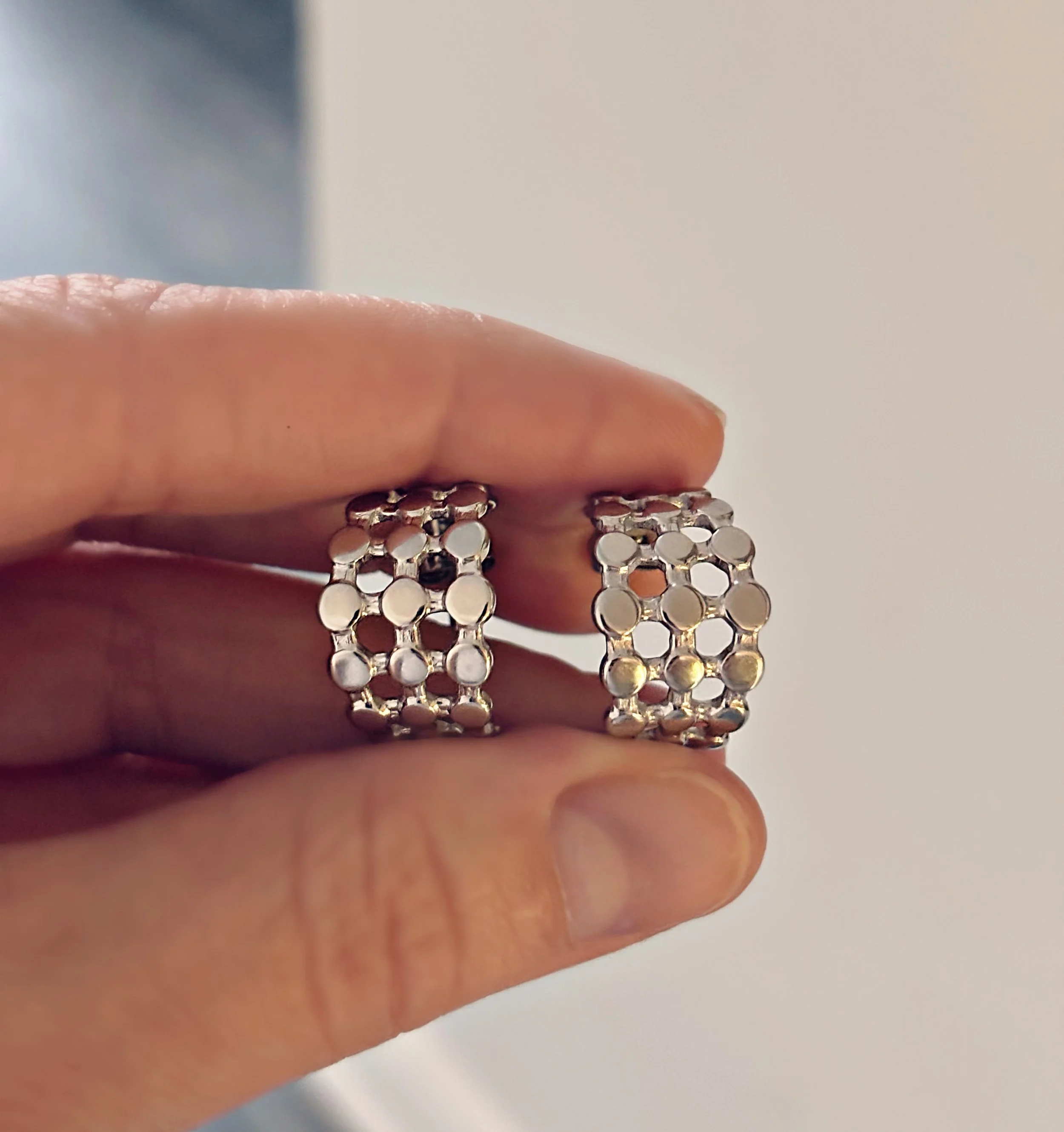 Boucles d’oreilles Nyssa en acier inoxydable argentées, texture pastilles brillantes vues de près – Tokade