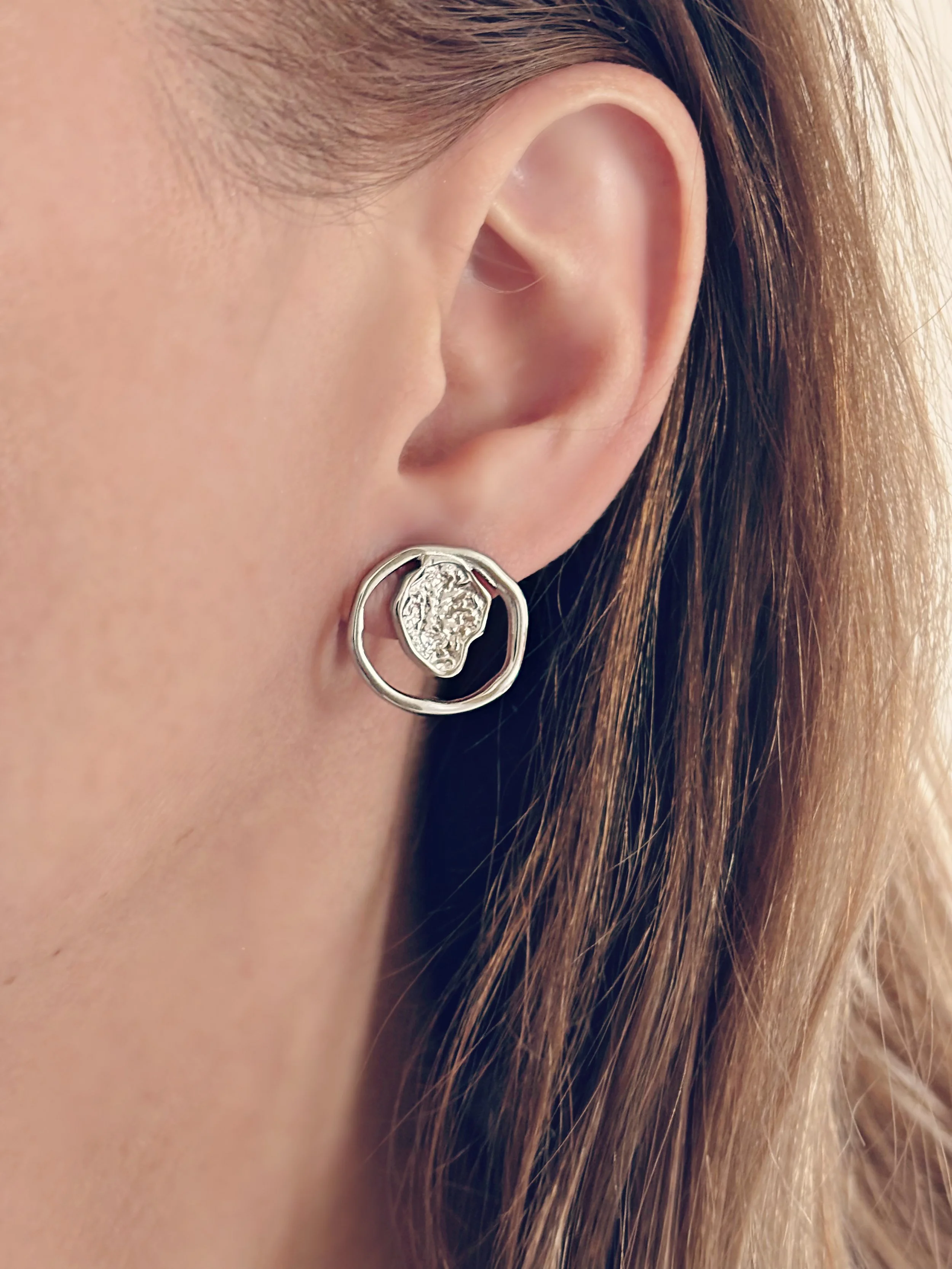 Boucles d’oreilles Aria portées, mettant en valeur leur design unique et texturé.