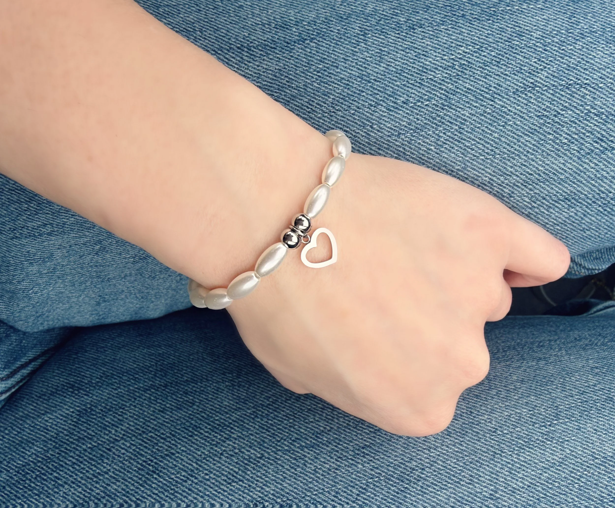 Bracelet perles blanches avec cœur argenté porté au poignet-Tokade