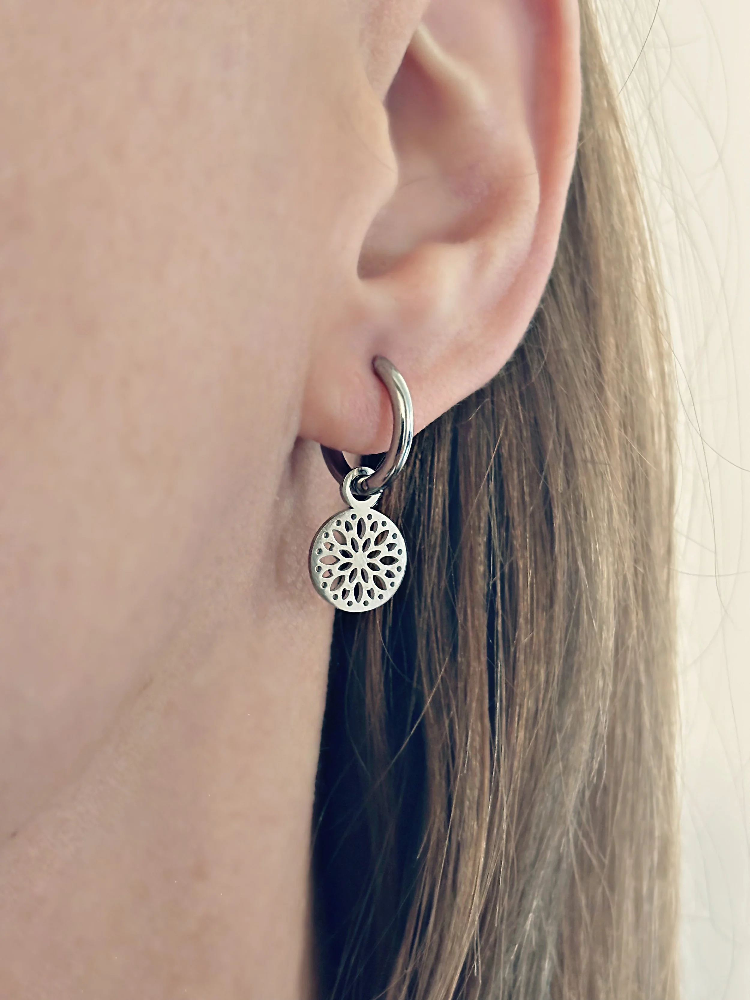 Boucles d’oreilles Solia tenues en main, mettant en valeur le design délicat.