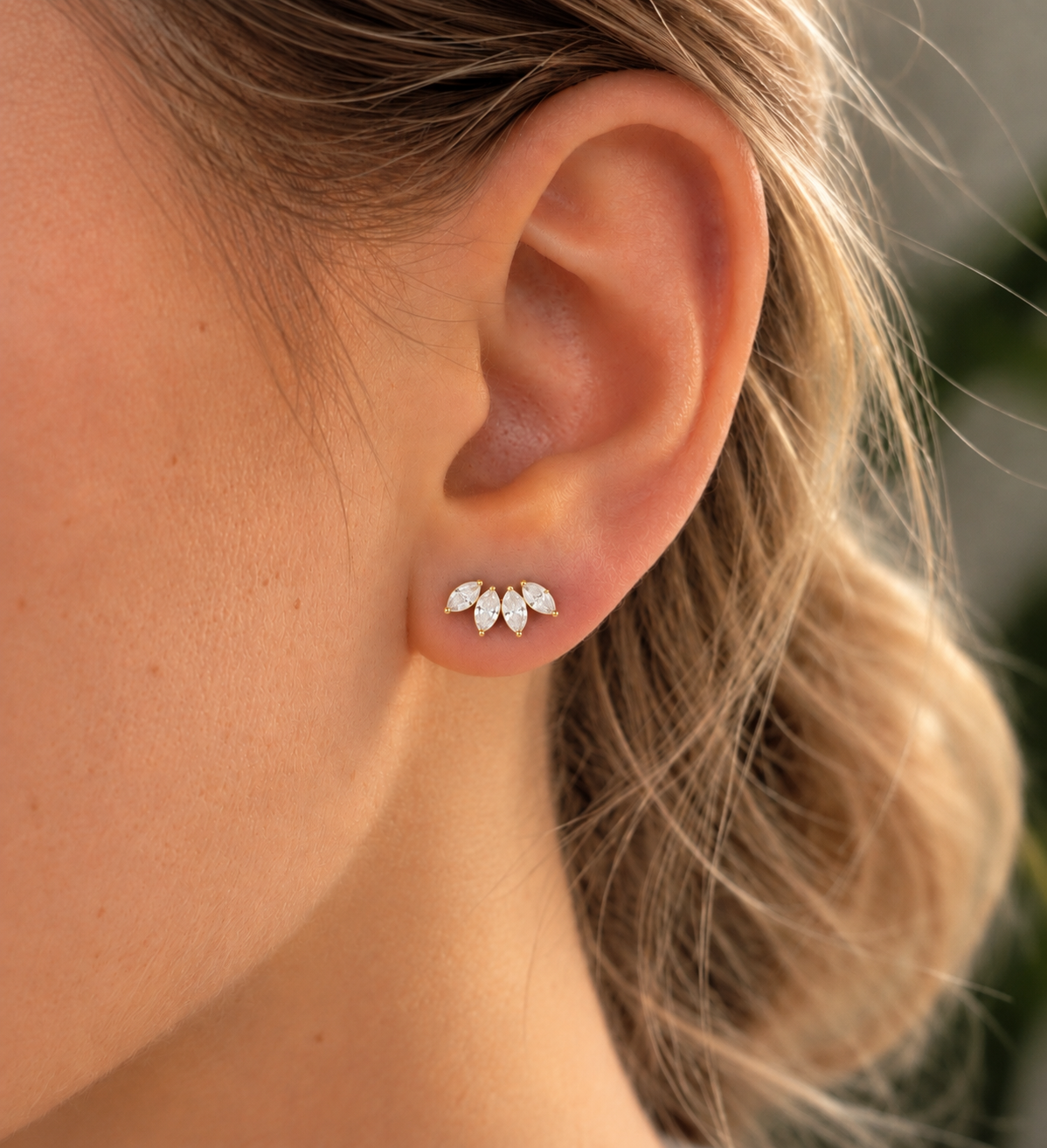 Boucles de piercing Ingrid dorées avec pierres en forme de feuilles portées au lobe