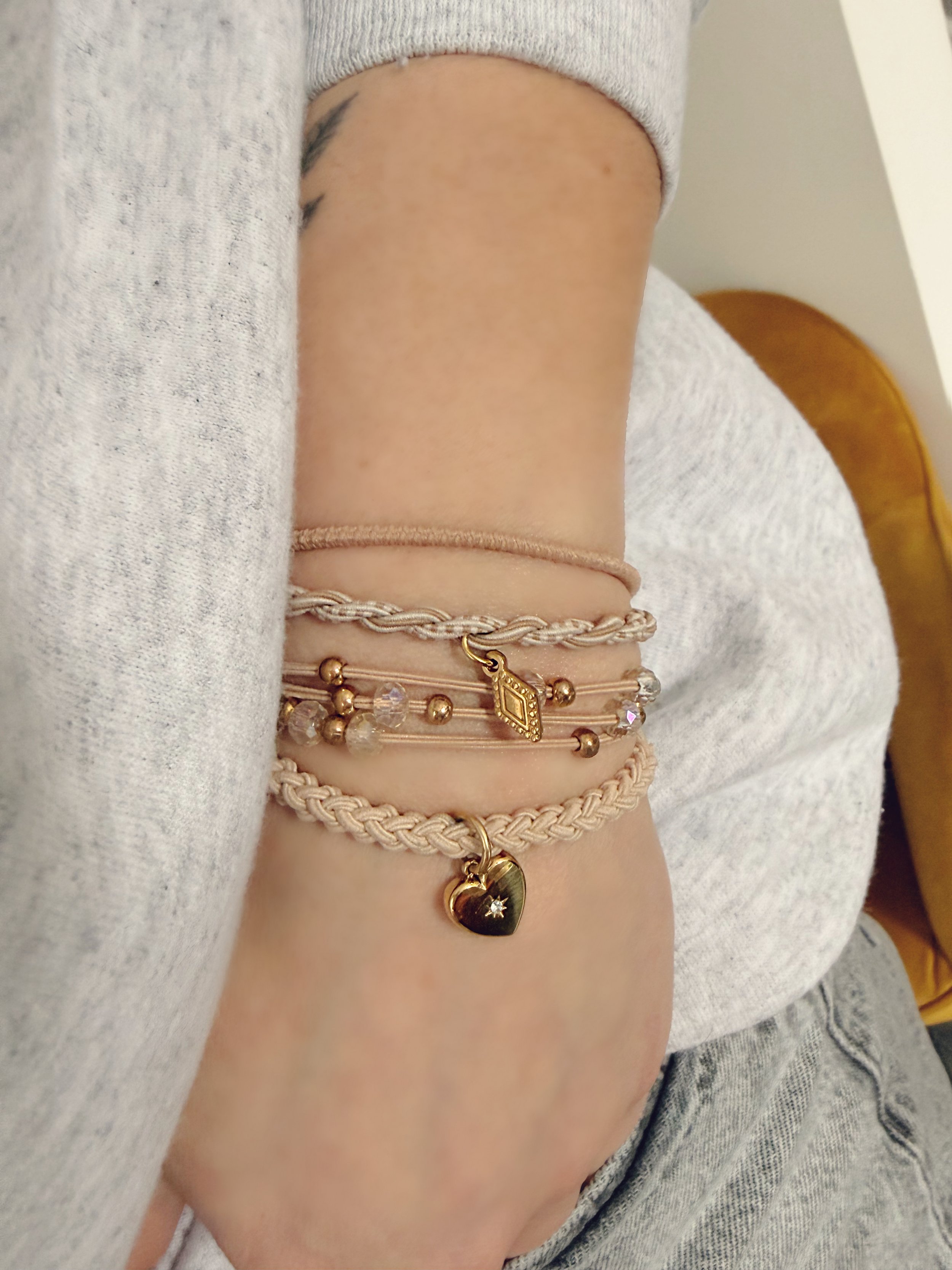Élastiques à cheveux portés en bracelets au poignet, avec breloques délicates dorées, accessoire mode féminin et polyvalent.-tokade