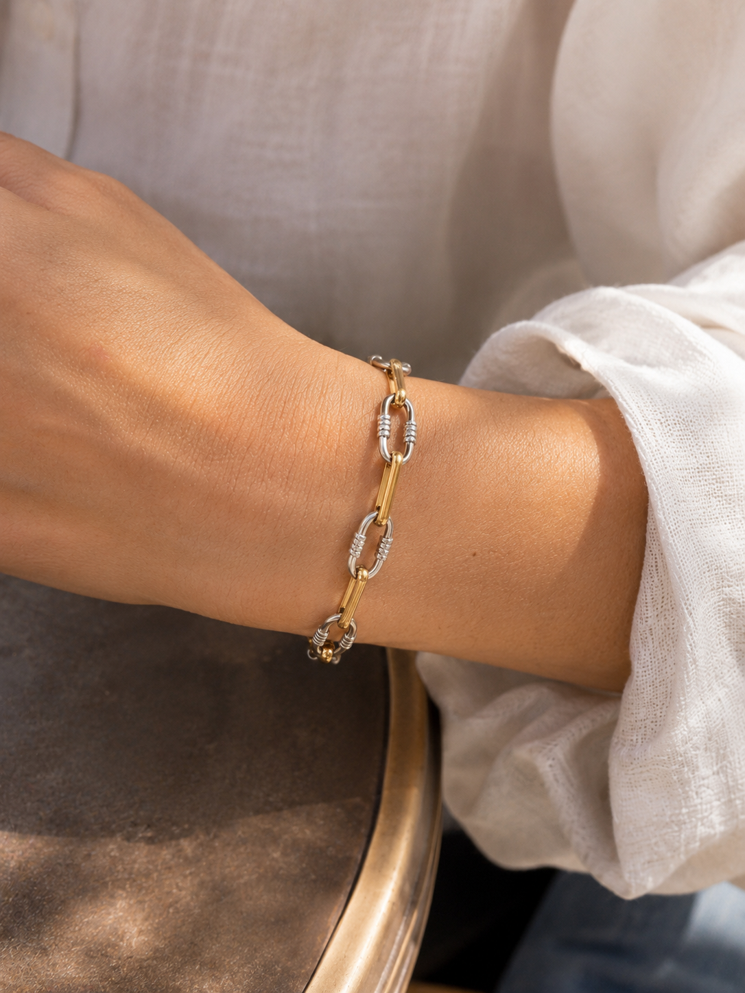 Bracelet Melba en acier inoxydable doré et argenté porté au poignet d’une femme. - Tokade