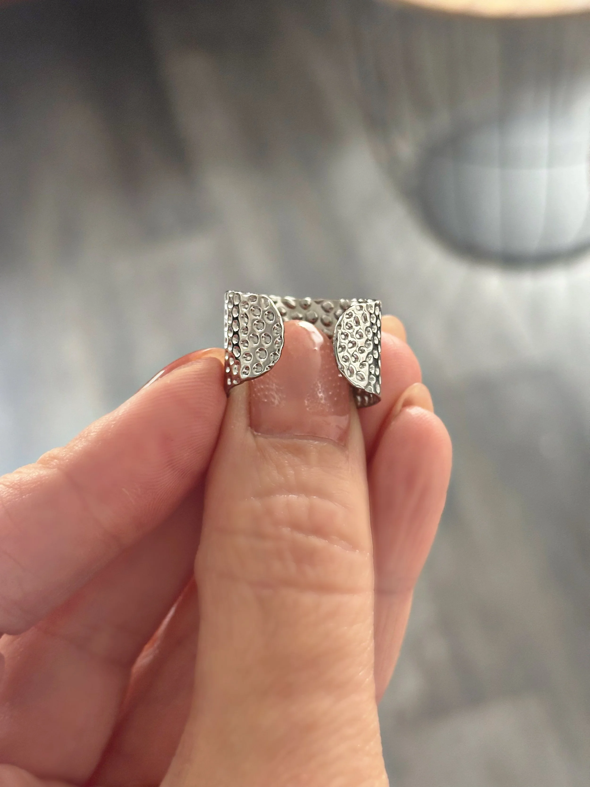 Gros plan de la bague tenue en main, illustrant la finition en relief.