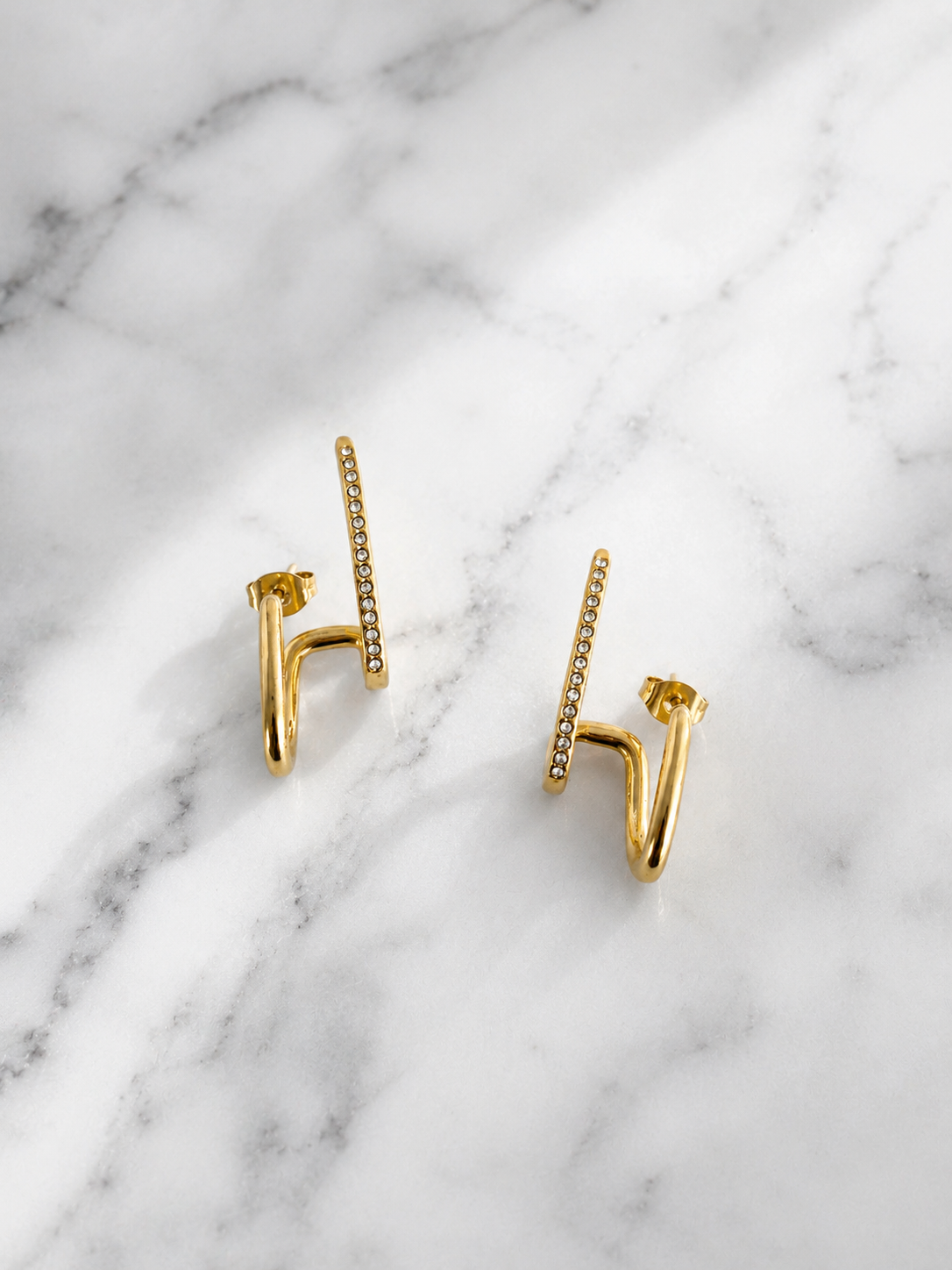 Boucles d’oreilles dorées Heliana sur fond marbre blanc - Tokade