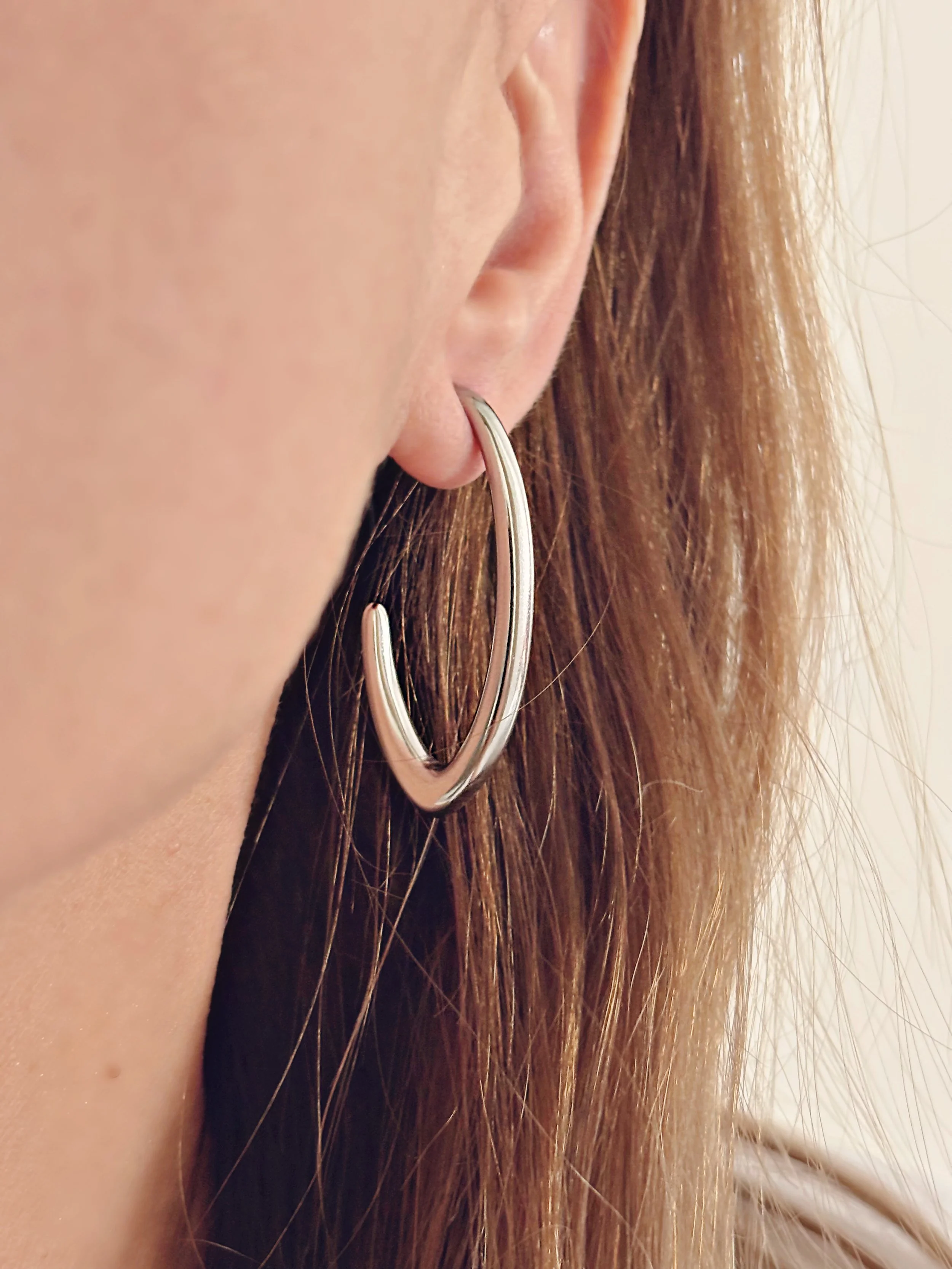 Boucles d’oreilles Amalia portées, mettant en valeur leur design moderne et élégant.