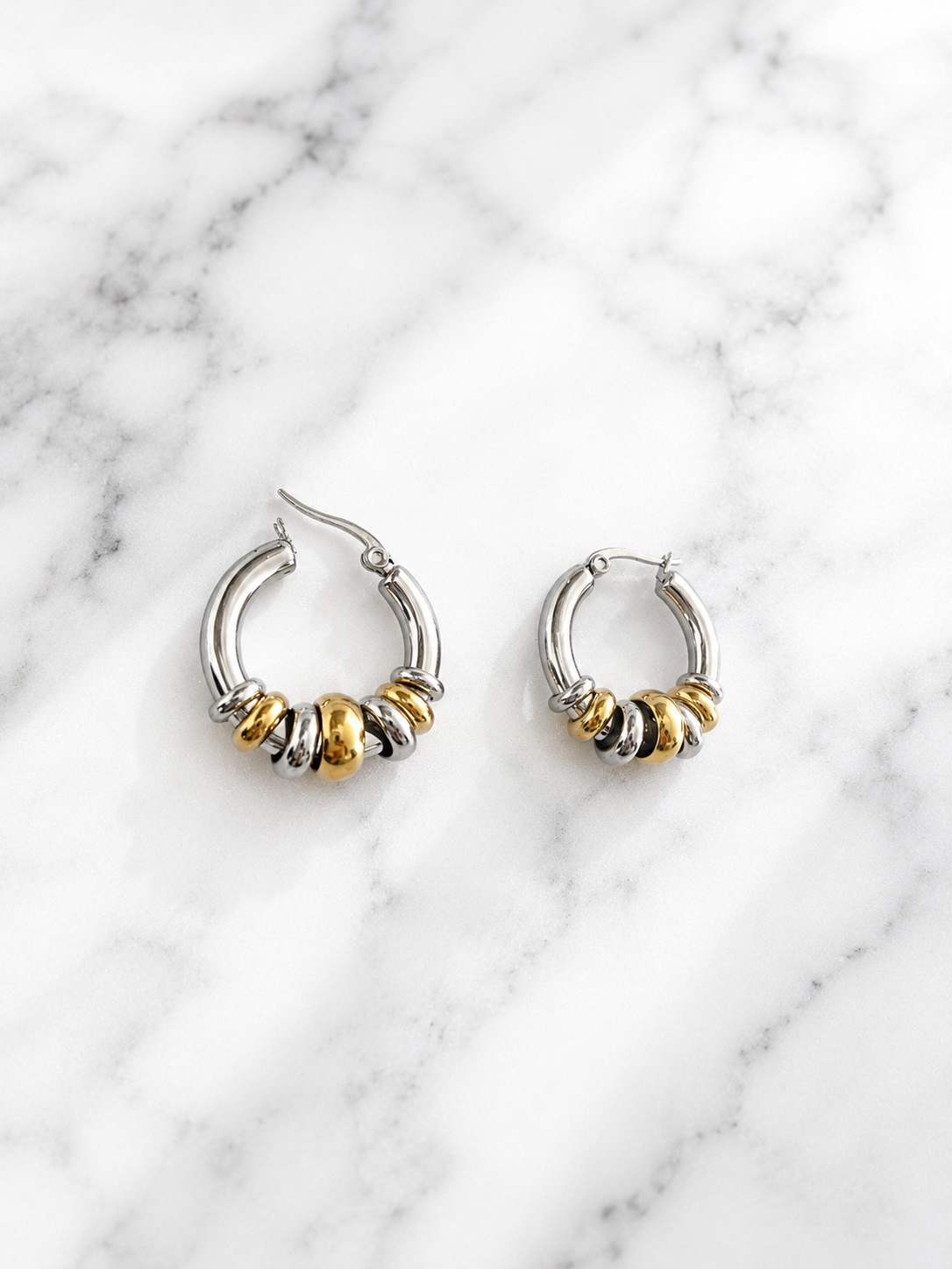 Boucles d’oreilles Debby deux tons en acier inoxydable sur fond de marbre blanc - Tokade