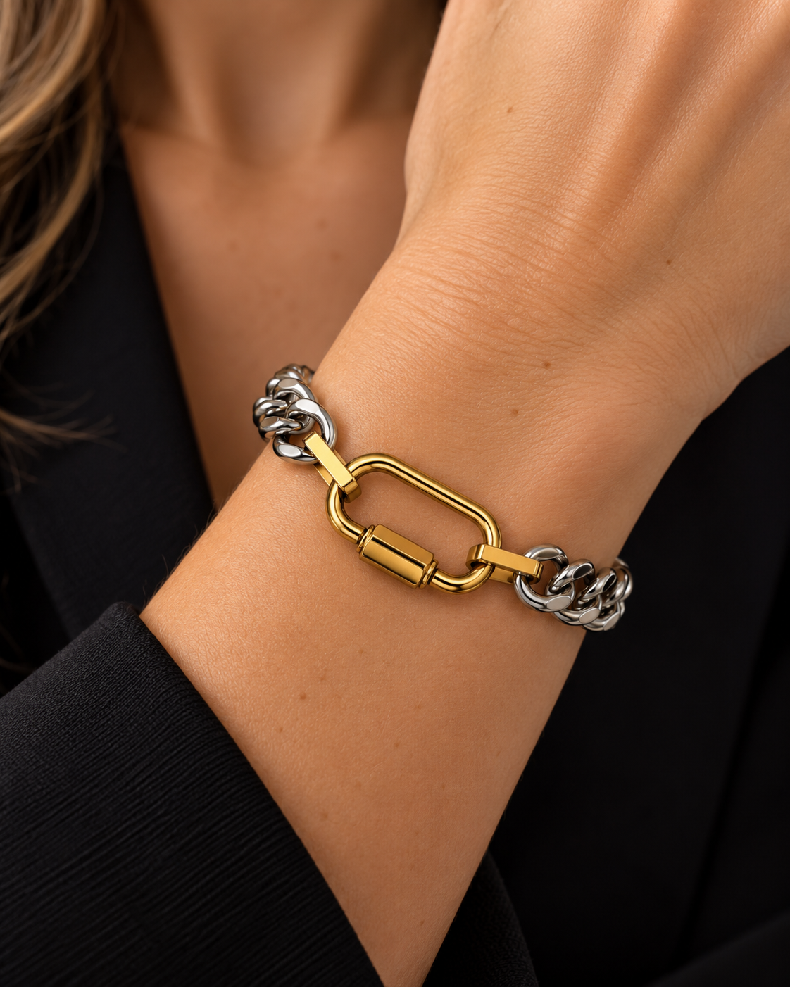 Bracelet Héra bicolore doré et argenté en acier inoxydable avec fermoir central à vis pour ajouter des breloques, porté sur un poignet féminin.
