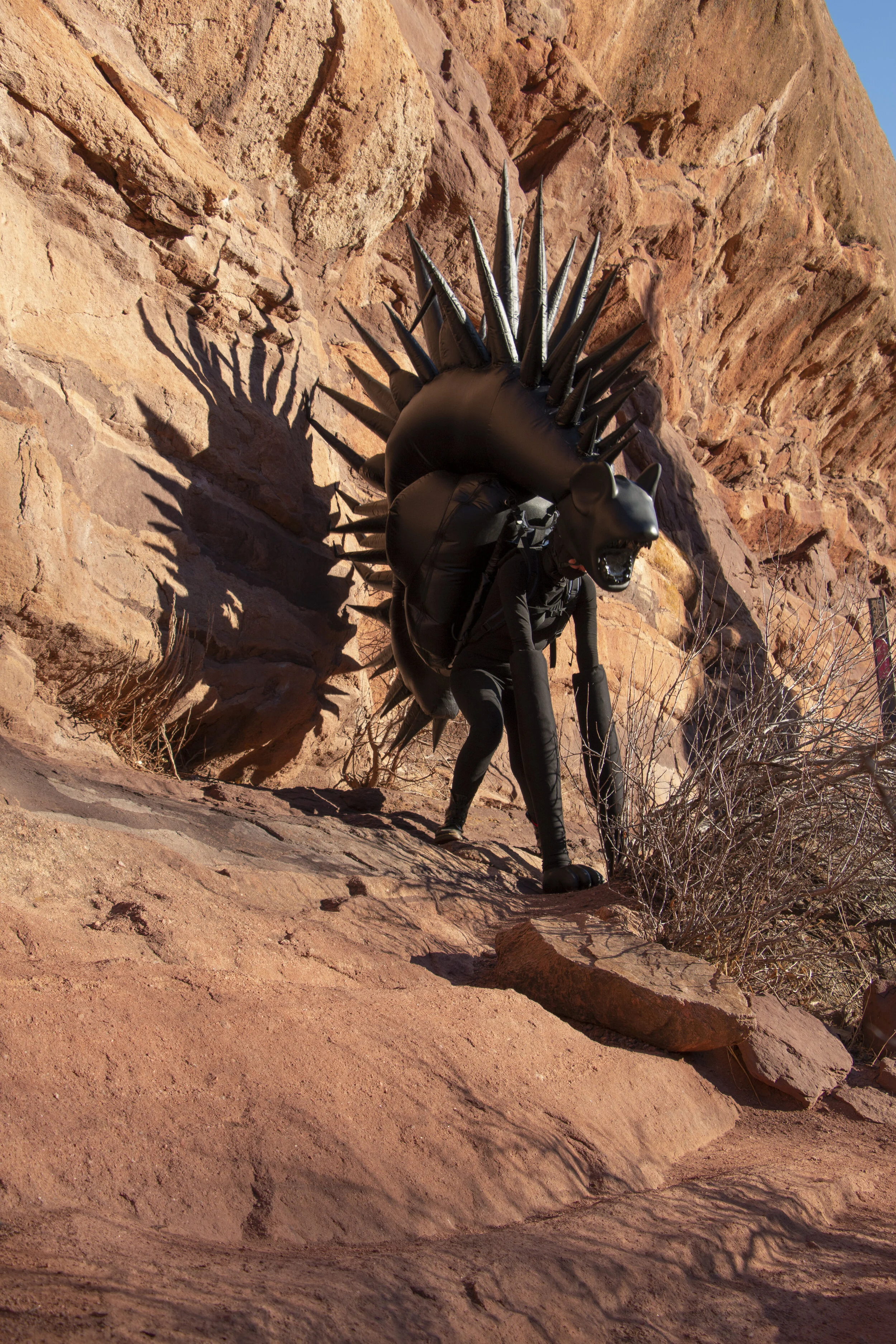 Inflatable fabric sculpture hyena beast performance in Red Rocks