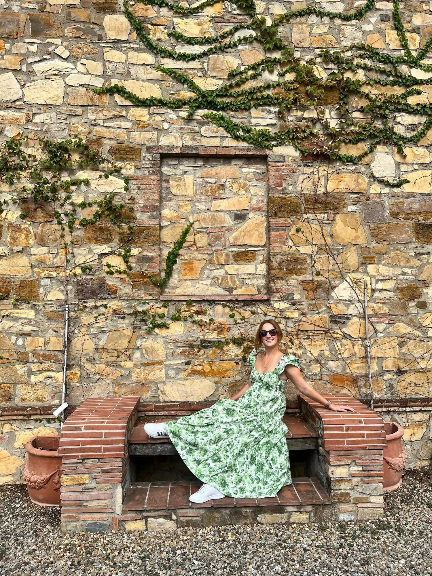 woman in green floral dress and sneakers at winery in tuscany