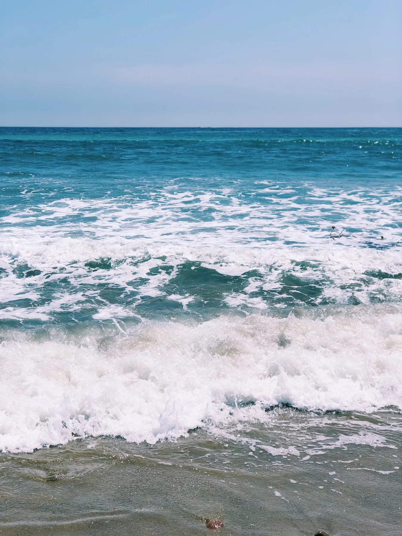 Ocean wave breaks on sand
