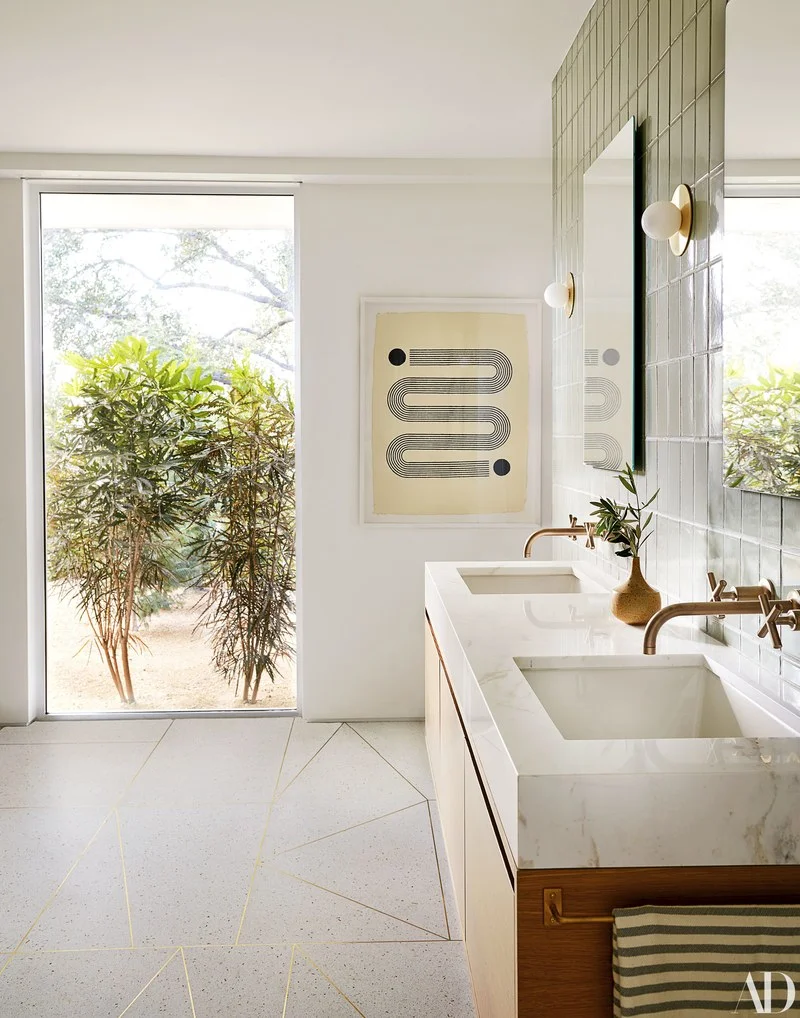 This bathroom has the flooring of our dreams! Love the custom brass inlay set in terrazzo & the volakas marble-topped vanity.