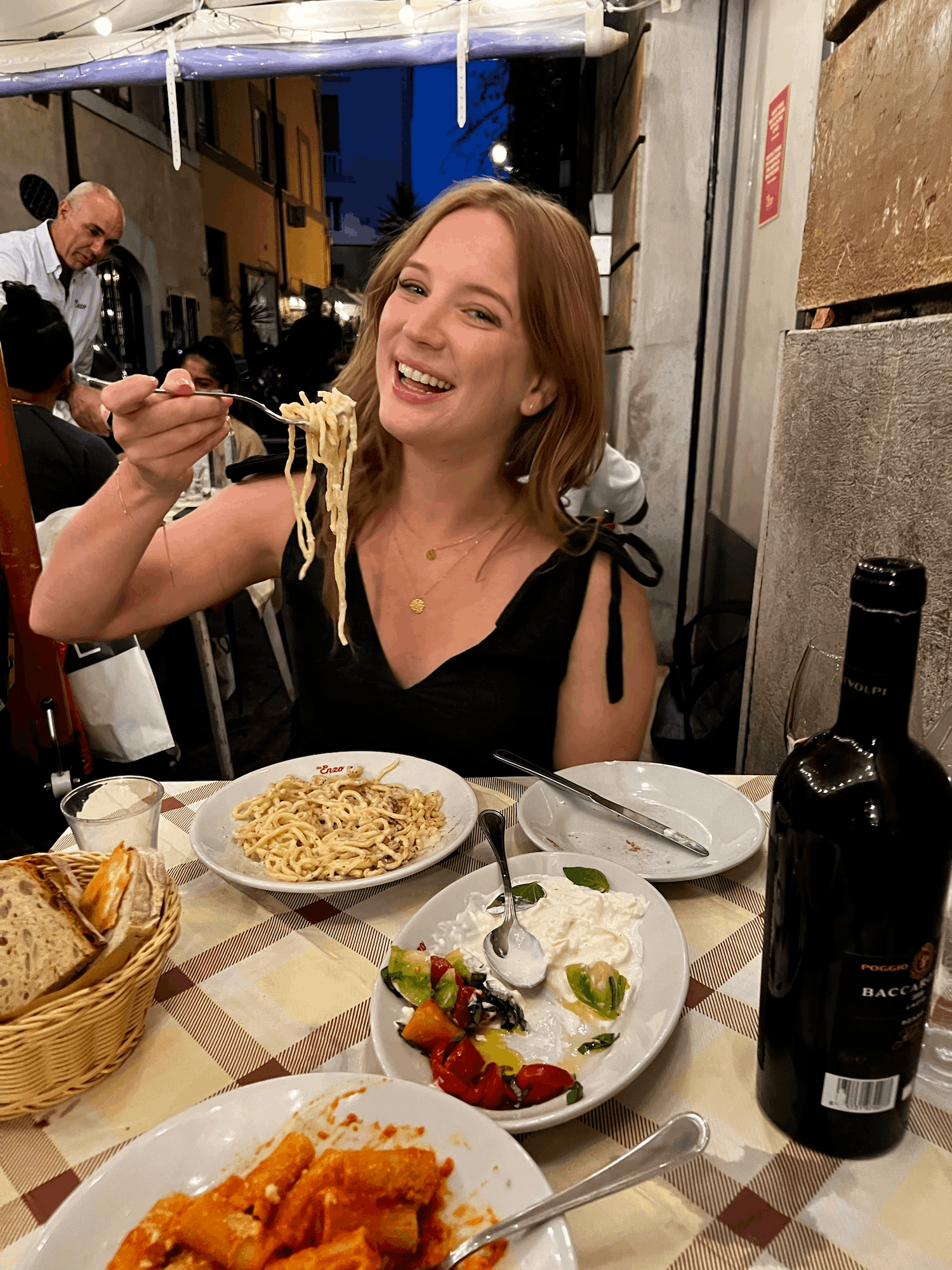 woman smiling while eating pasta in Rome Italy at Da Enzo al 29