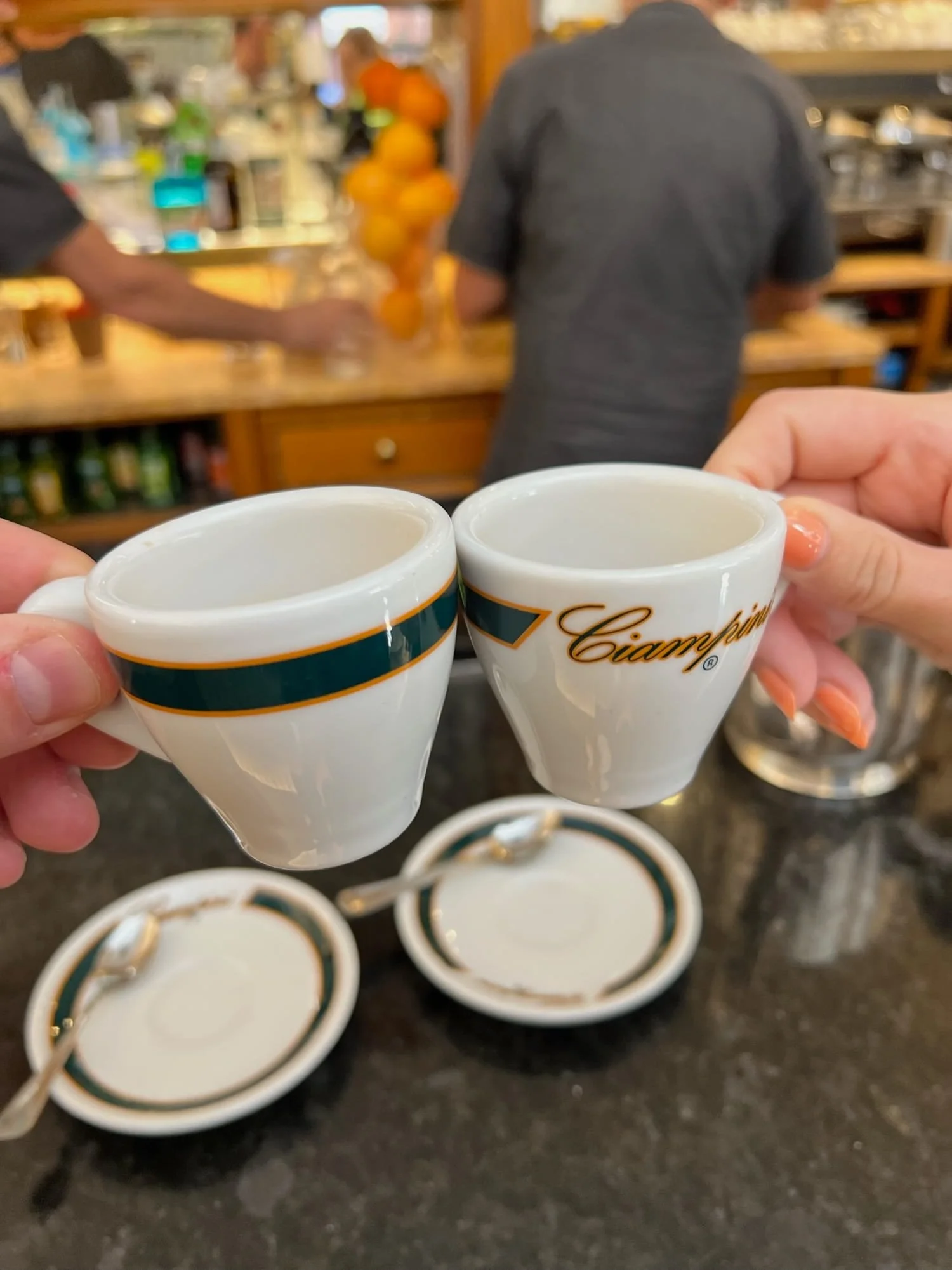 drinking espresso while standing at the bar and clinking cups in rome italy