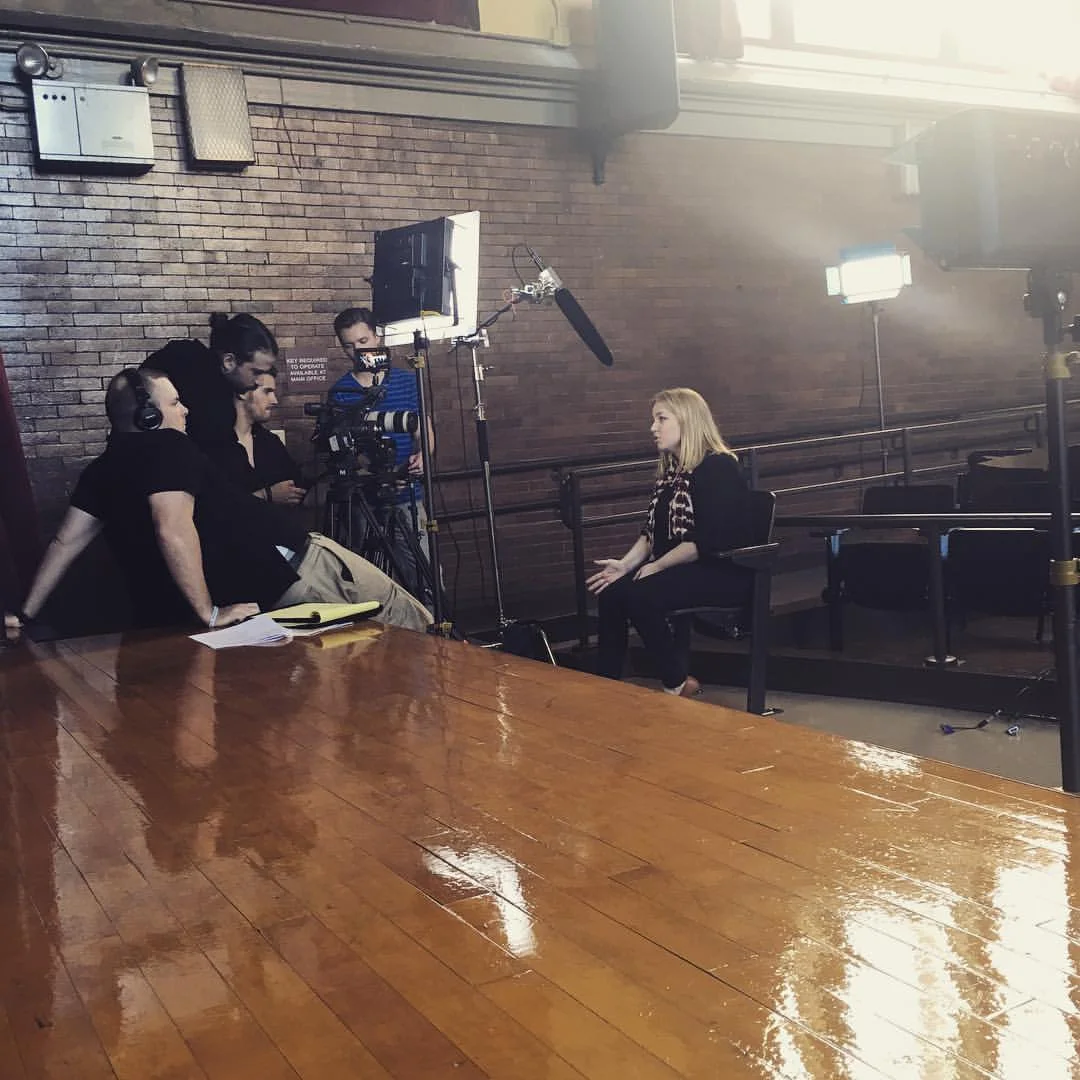 Harper in an interview with WTTW Chicago Public Media in the Bernhard Moos Elementary School auditorium about the work of children.