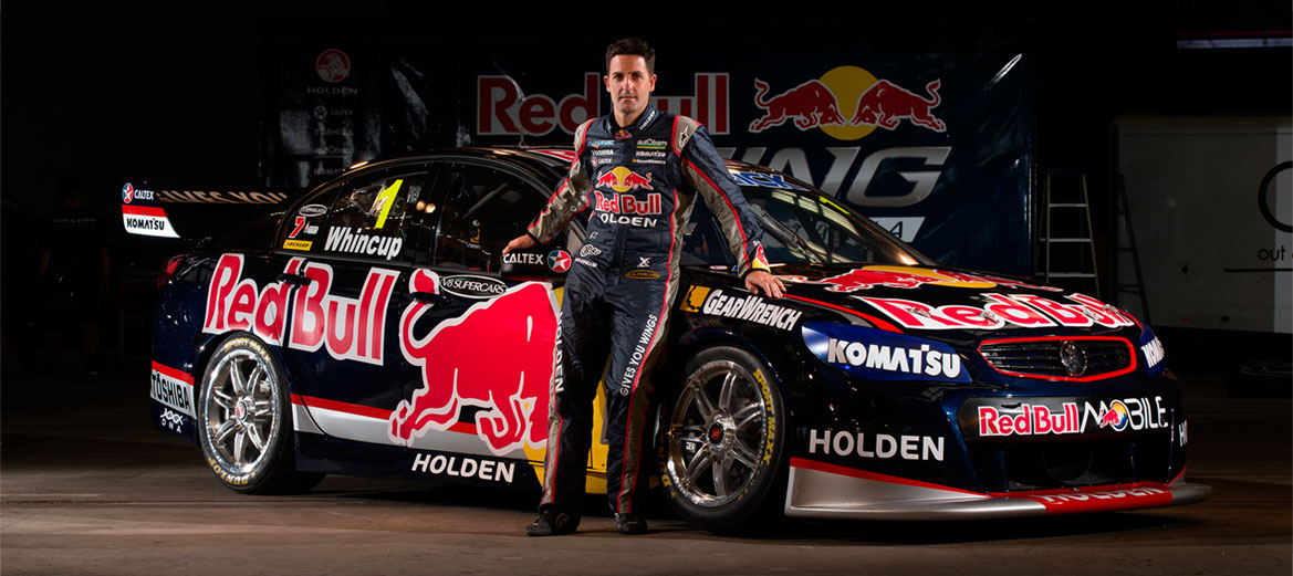 V8 Supercars champion driver Jamie Whincup stands besides the Triple Eight vehicle.