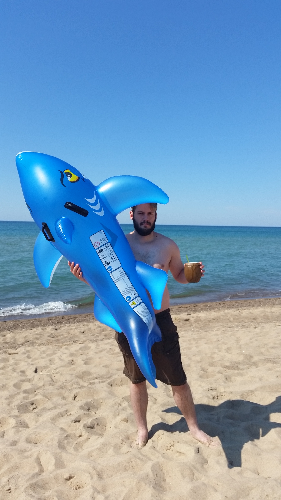 Jason enjoying a beverage & our shark floatie after a swim