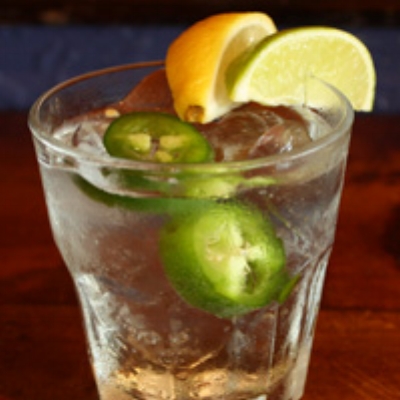 Ingredients: 1½ oz Pura Vida Reposado Tequila One Fresh Lime Wedge One Fresh Lemon Juice 3 oz Topo Chico (Mineral Water) Two Fresh Jalapeño Slices In a shaker with ice, combine tequila, juice of lime and lemon wedges. Shake to combine. Pour into a highball glass filled with ice and top with Topo Chico. Add two fresh jalapeño slices.