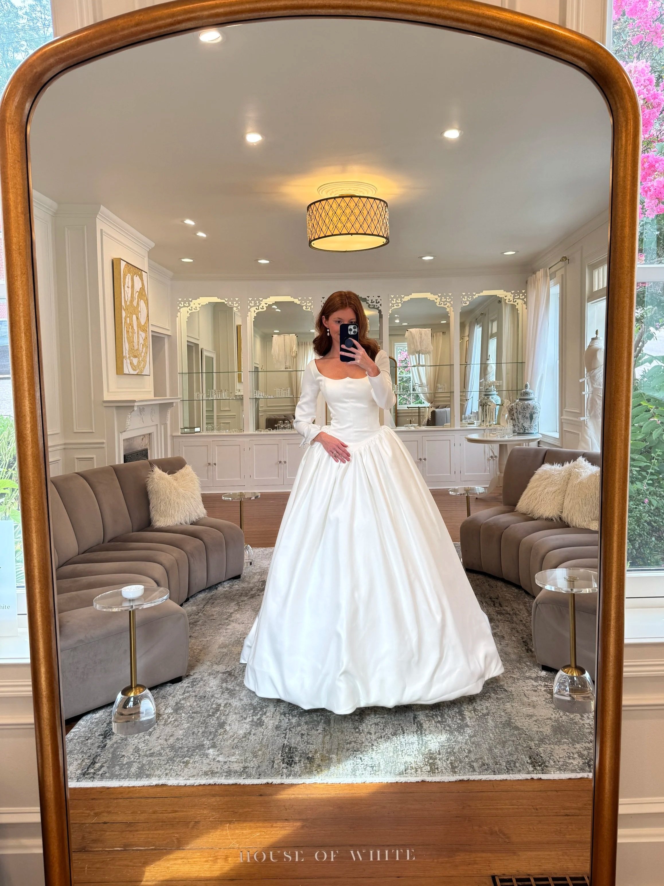 A model wears a satin long sleeve gown in the main styling room of House of White, a luxury bridal boutique in Newburgh Indiana