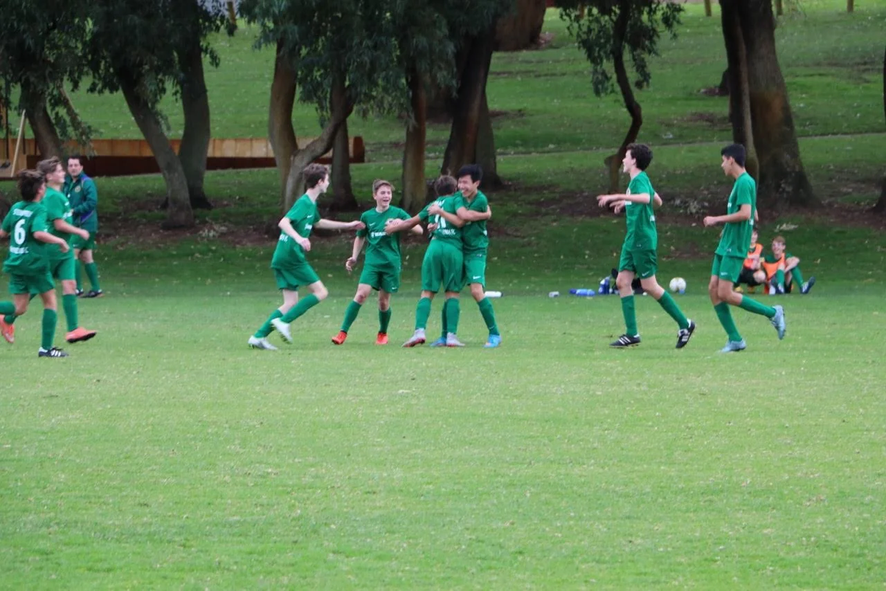 The 14 boys celebrate their winner against Wembley Downs 