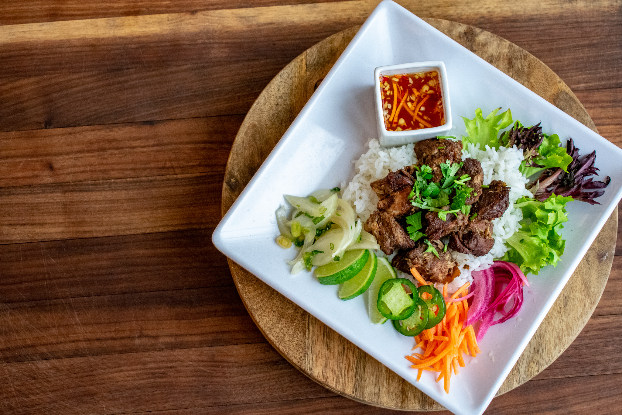 Five-Spiced Braised Pork rice bowl with fresh vegetables & lime