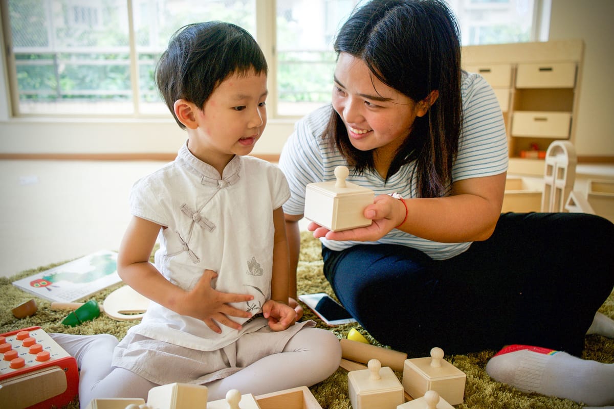 Yiuxuan He, 2 years and 10 months old, has just started at the Finnish kindergarten in Guangzhou. His teacher Lucy Lu is encouraging him to play. Picture: Matti Hämäläinen / Yle
