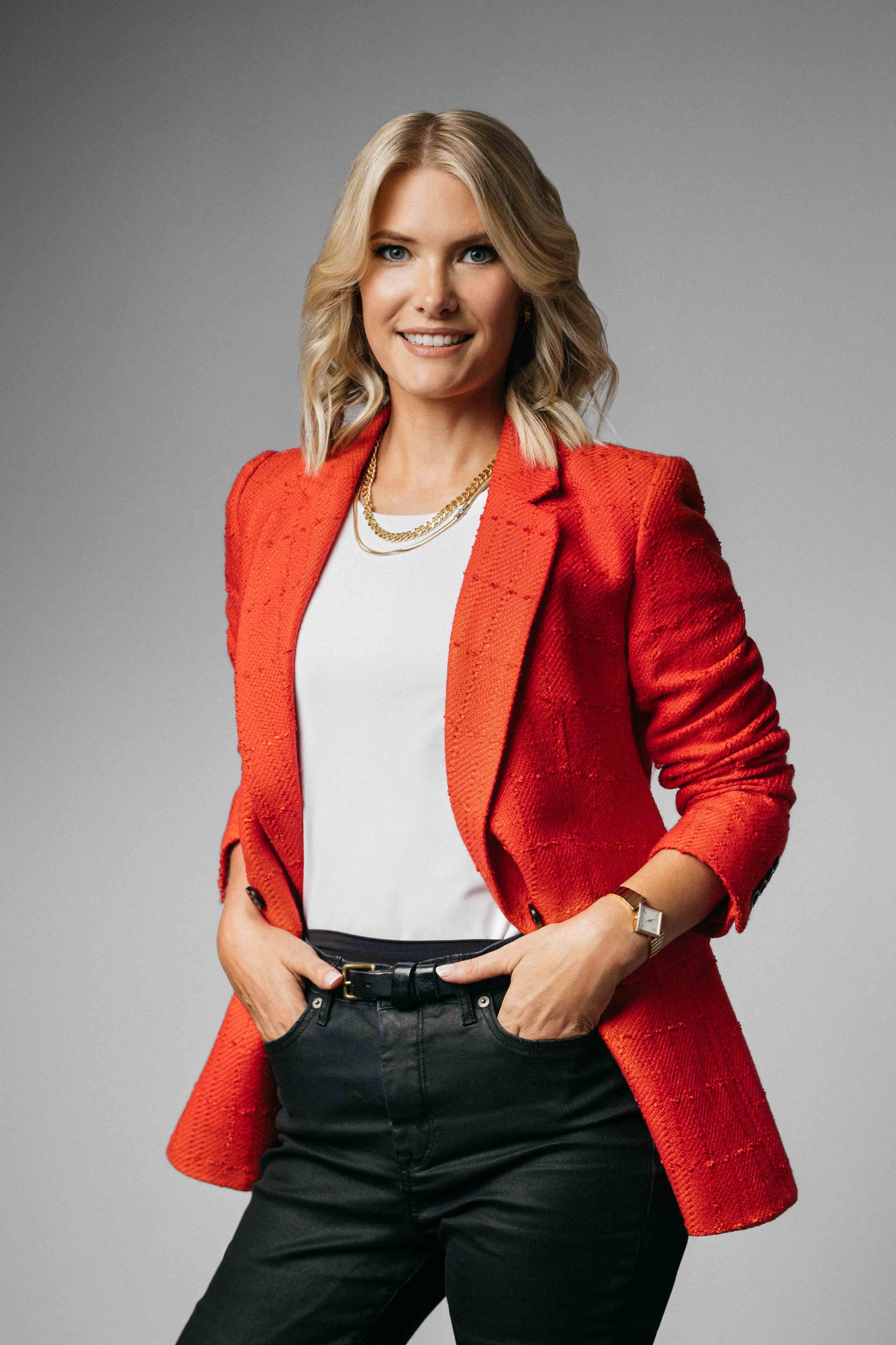 Stylish female professional portrait in studio, posing with relaxed confidence and editorial lighting for personal brand images.