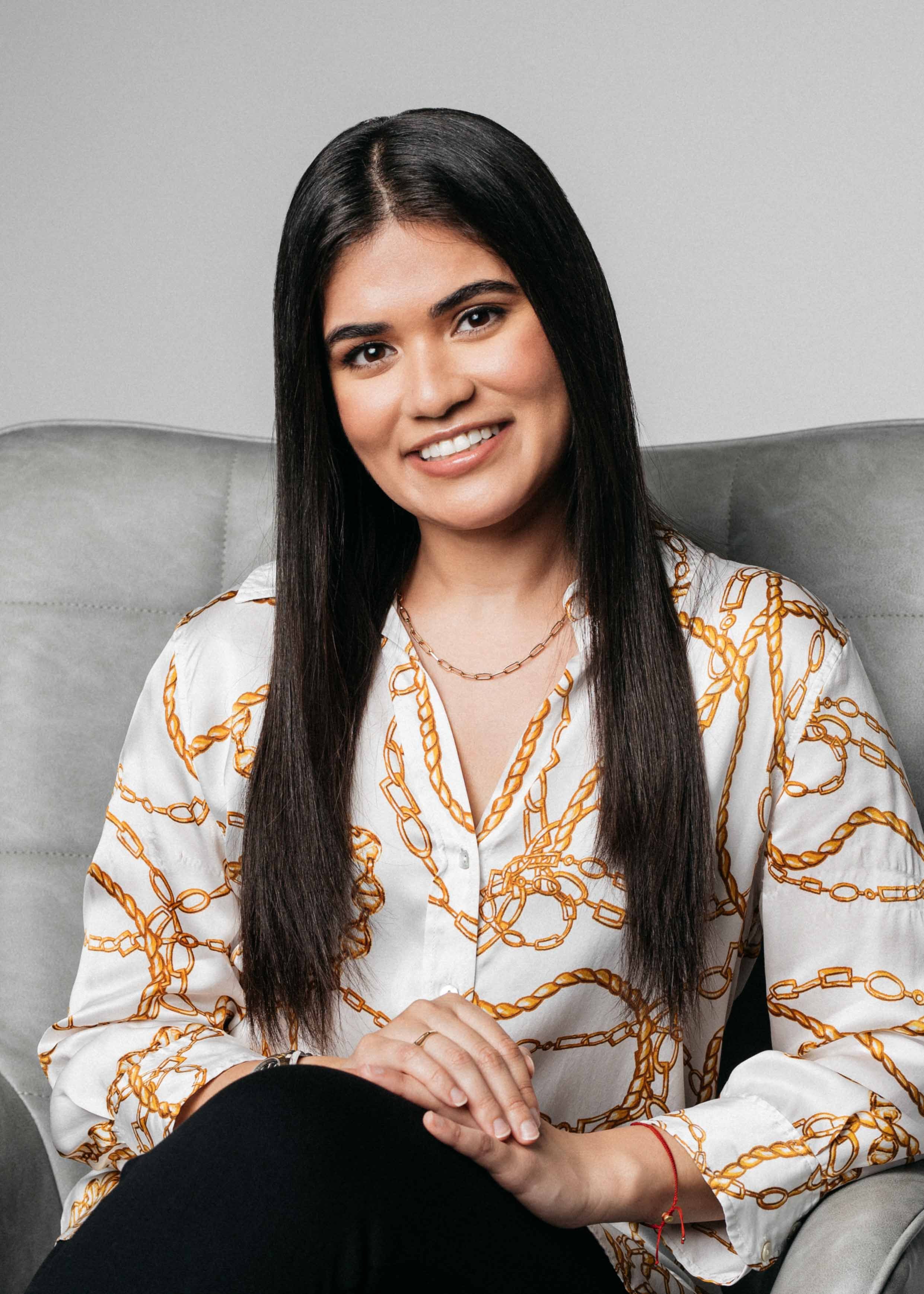 A young woman laughs naturally during studio personal branding session.